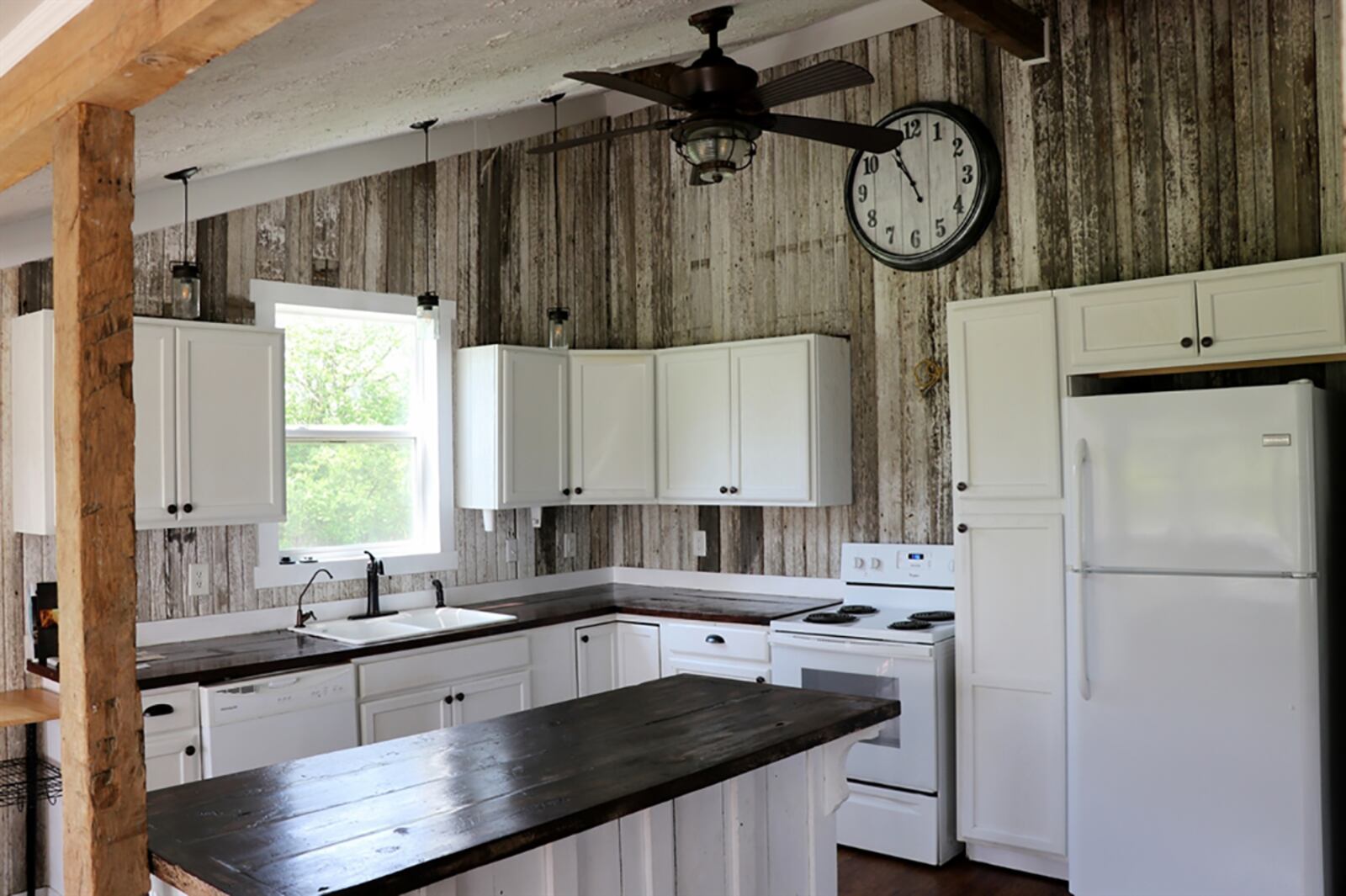 A vaulted ceiling extends above the kitchen and reused barn siding accents the wall space above the white cabinetry. Refinished butcher-block wooden countertops are a rich walnut color that complements the white cabinets. CONTRIBUTED PHOTO BY KATHY TYLER