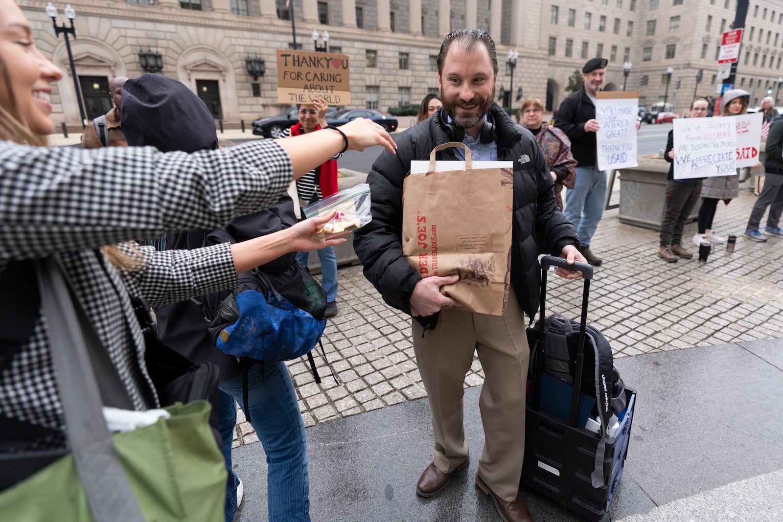 United States Agency for International Development (USAID) worker Donato Corsini carries personal belongings after retrieving them from USAID's headquarters in Washington, Thursday, Feb. 27, 2025. (AP Photo/Manuel Balce Ceneta)