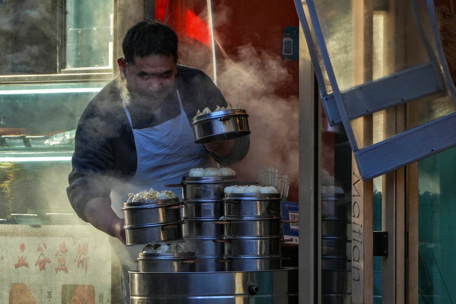 A vendor prepare steam dumplings and buns at a restaurant in Beijing, Thursday, March 6, 2025. (AP Photo/Andy Wong)