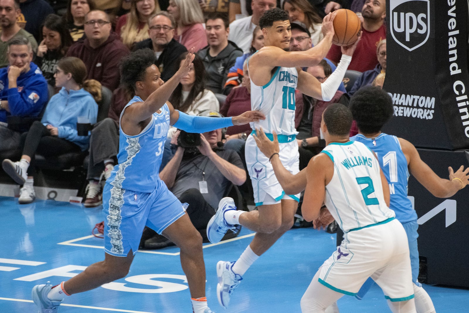 Charlotte Hornets' Josh Green (10) looks to pass the ball as Cleveland Cavaliers' Isaac Okoro, left, defends while Hornets' Grant Williams (2) and Cavaliers' Jarrett Allen, right, watch during the first half of an NBA basketball game in Cleveland, Sunday, Nov 17, 2024. (AP Photo/Phil Long)