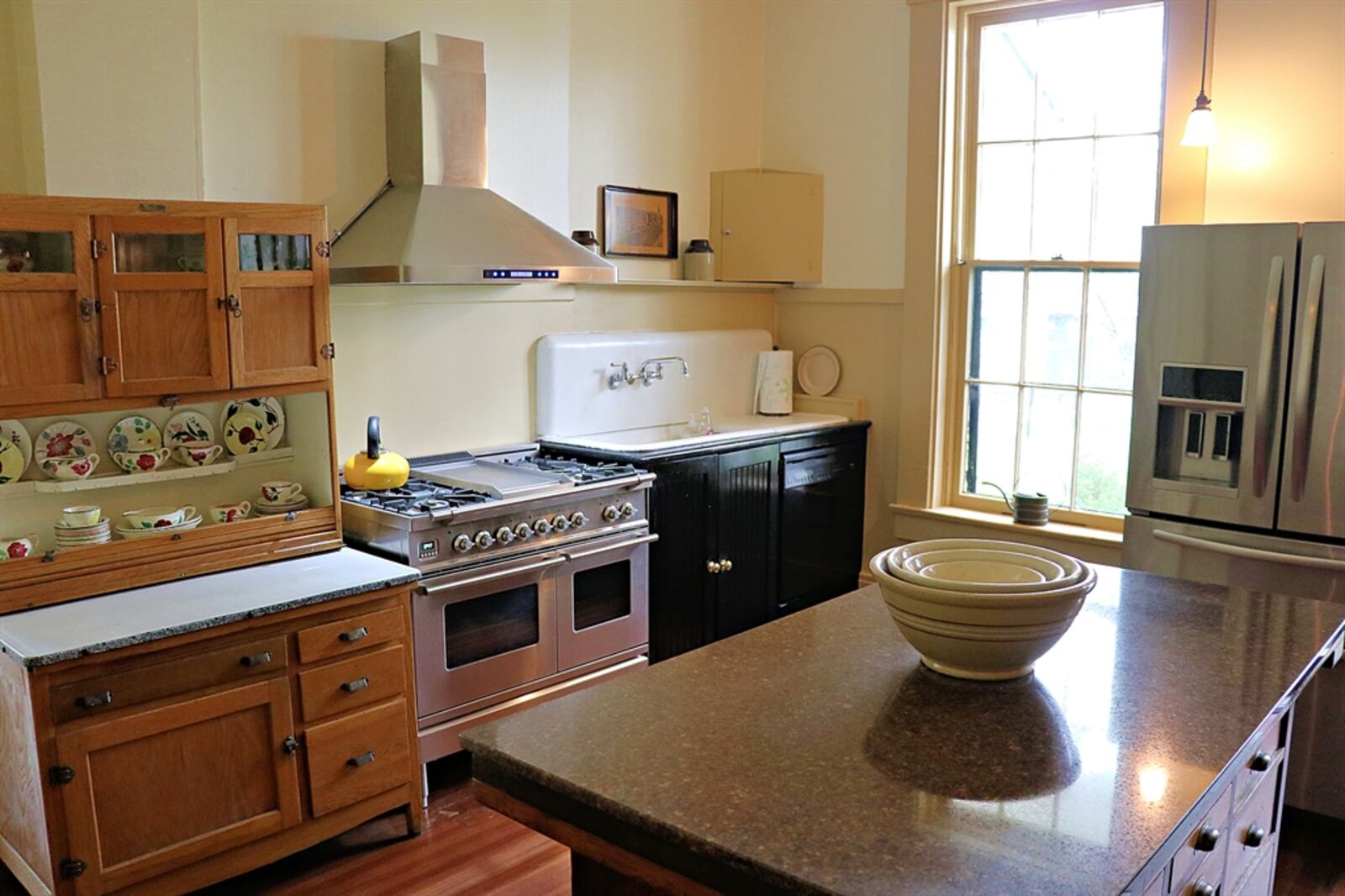 The kitchen has updated appliances that blend within original cabinetry and has a back staircase and access to a laundry room. 