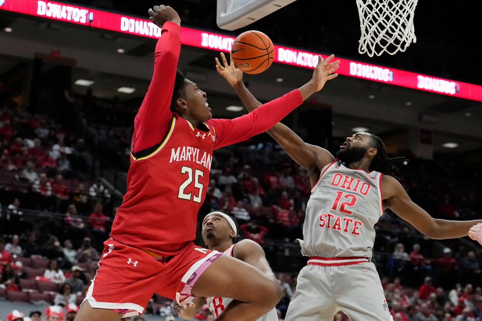 Maryland center Derik Queen (25) loses the ball in front of Ohio State guards Micah Parrish, center, and Evan Mahaffey (12) in the first half of an NCAA college basketball game Thursday, Feb. 6, 2025, in Columbus, Ohio. (AP Photo/Sue Ogrocki)