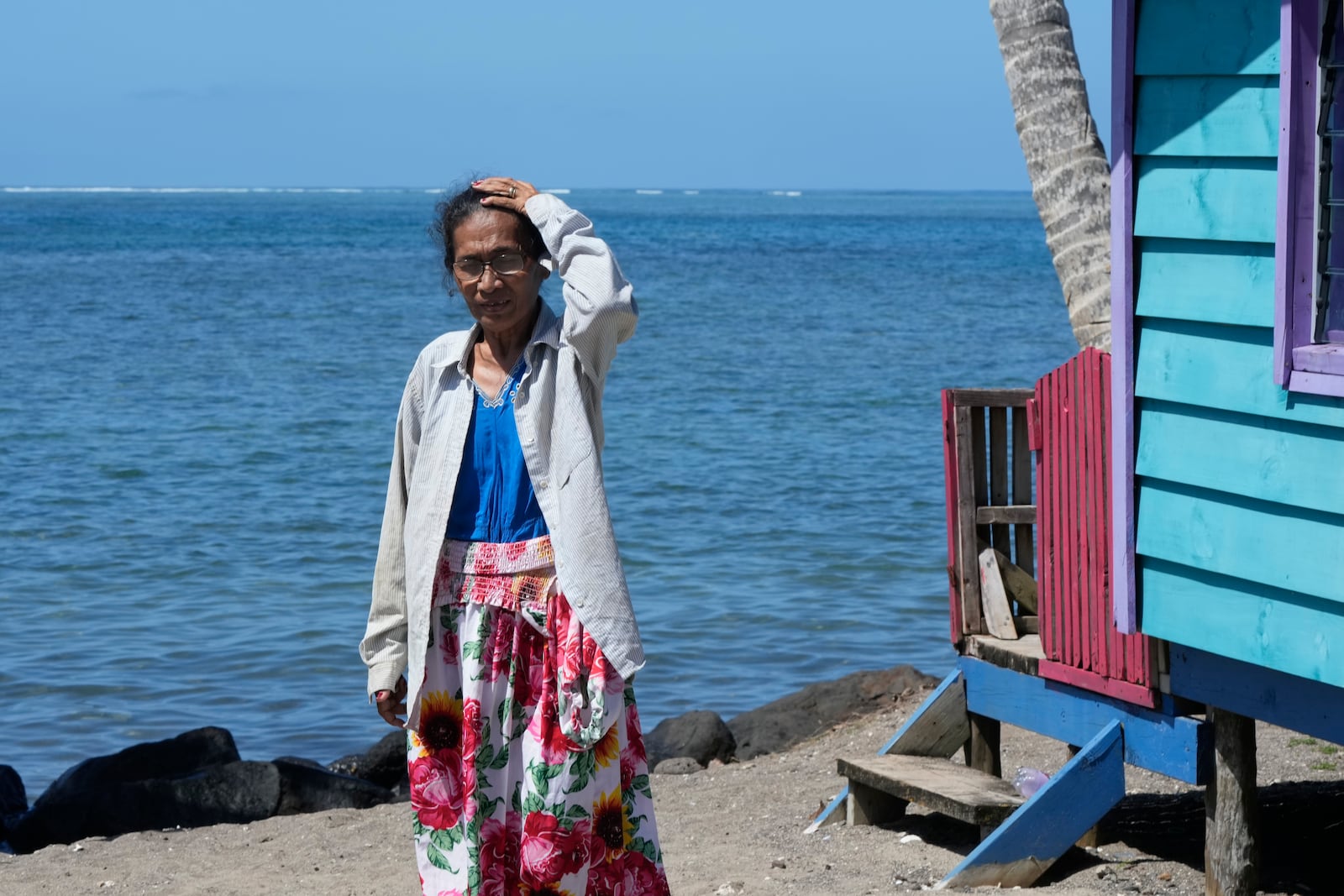 Netina Malae walks past a hut at her Sima PJ Beach Fale resort in the village of Tafitoala, Samoa, on Monday, Oct. 21, 2024, near where a New Zealand navy ship ran aground and sank on Oct. 6. (AP Photo/Rick Rycroft)