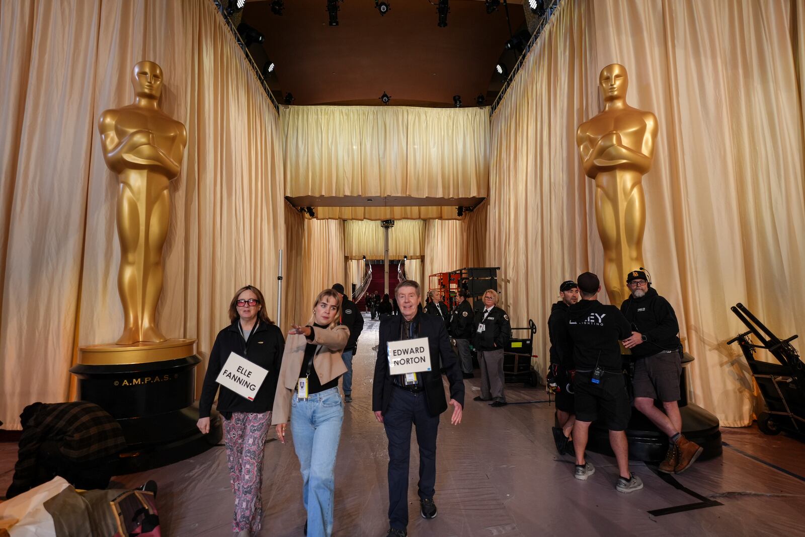 Stand-ins walk past Oscar statues in the red carpet area before the 97th Academy Awards in Los Angeles, Saturday, March 1, 2025. (AP Photo/Jae C. Hong)