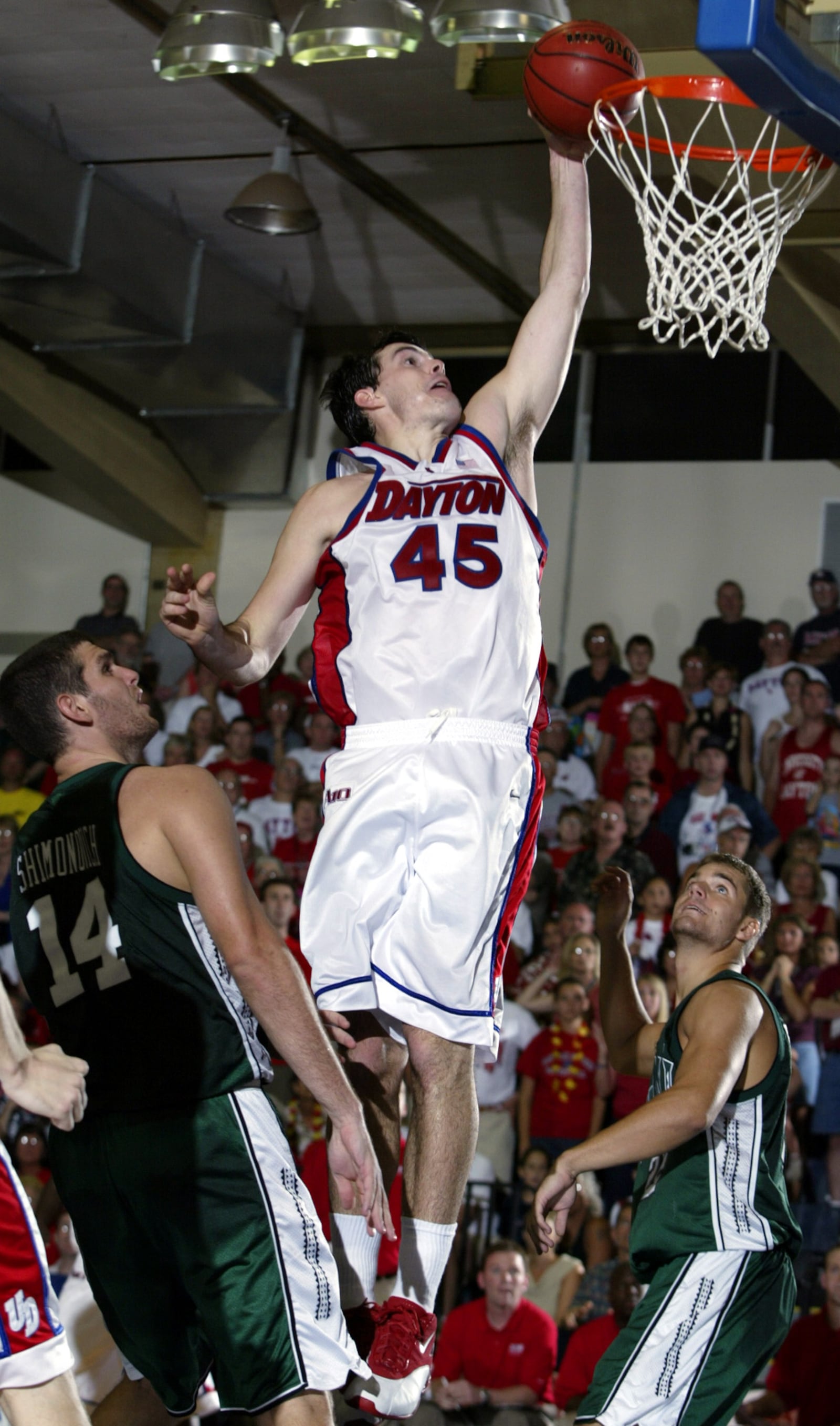 Dayton's Keith Waleskowski, center, gets a bucket on a slam dunk over Hawaii's Haim Shimonovich, left, and Logan Lee in the second half of the championship game at the Maui Invitational in Lahaina, Hawaii on Wednesday, Nov. 26, 2003. Waleskowski was named tournament MVP as Dayton defeated Hawaii, 82-72. (AP Photo/Michael Conroy)