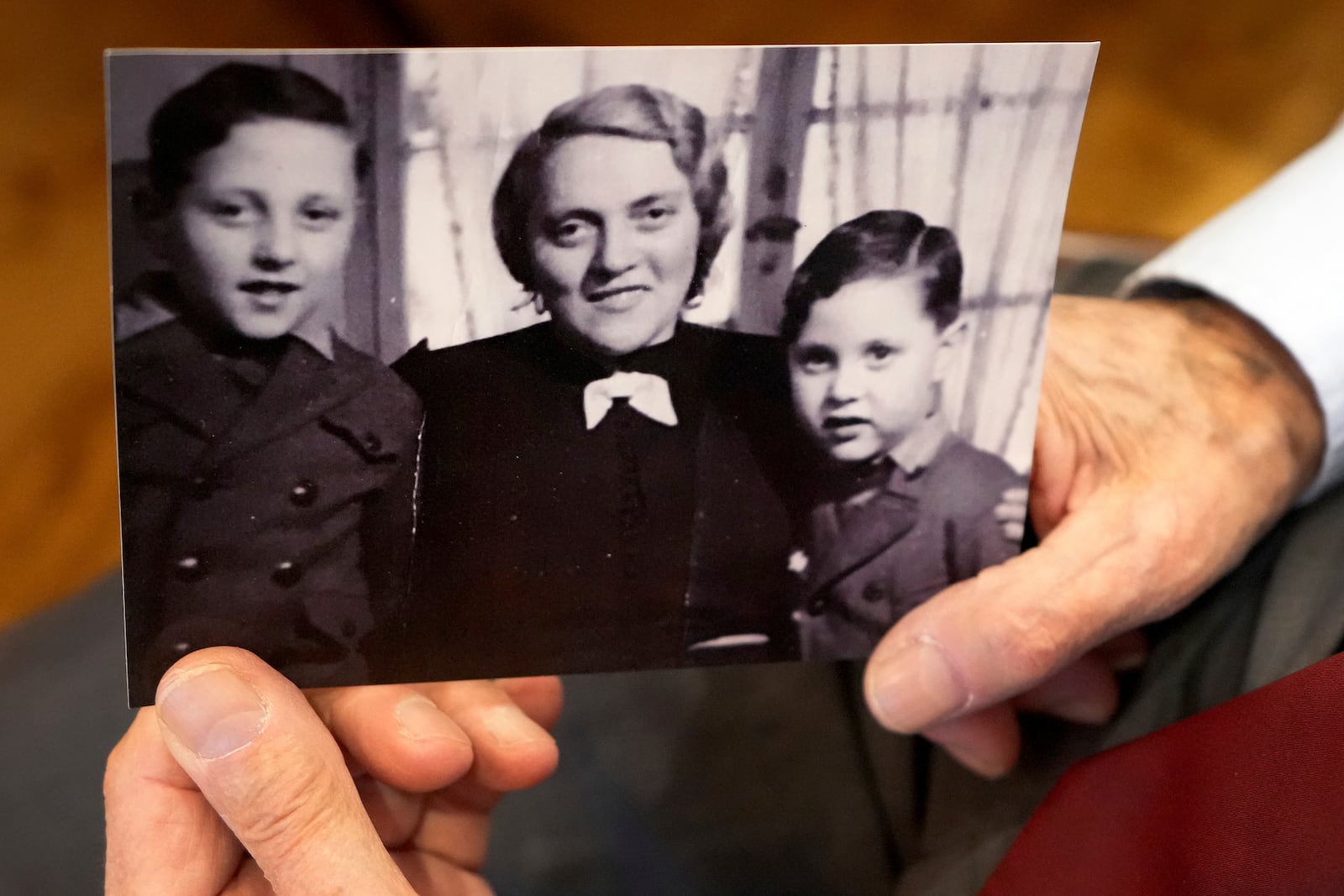 Manfred Goldberg, a Holocaust survivor displays a photograph of himself with his mother Rosa and younger brother Herman as he is interviewed in London, Wednesday, Jan. 22, 2025. (AP Photo/Kirsty Wigglesworth)