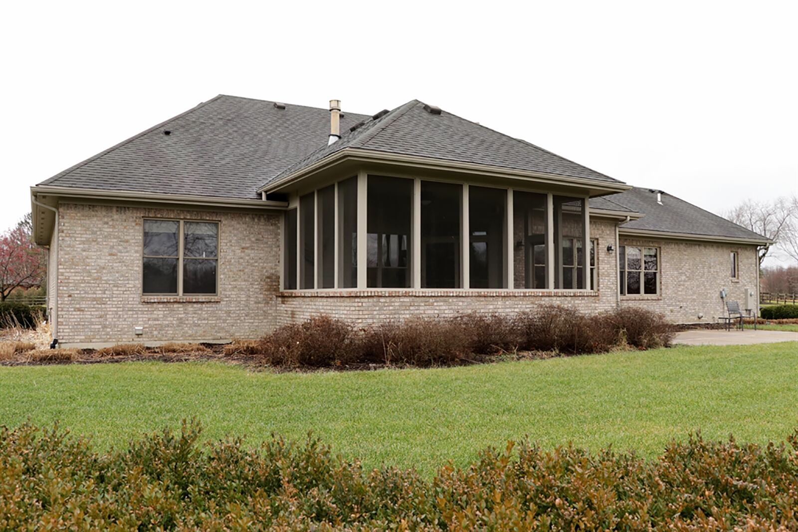 Mature trees line the back of the property, and mature landscaping surrounds the concrete patio while accenting the spacious, screen-enclosed porch. CONTRIBUTED PHOTO BY KATHY TYLER