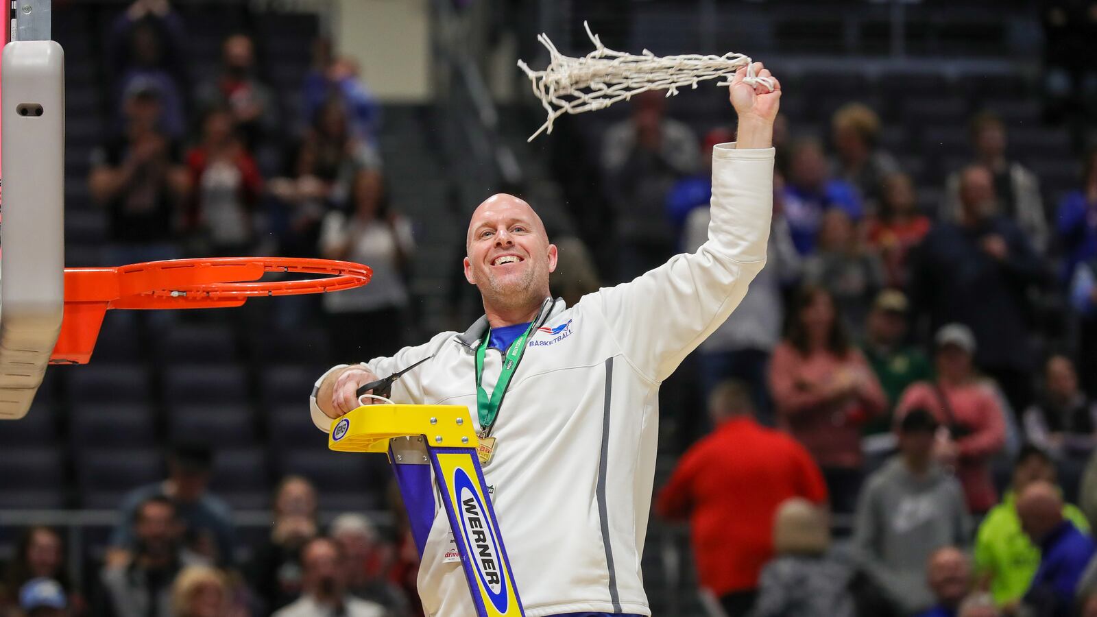 Tri-Village High School coach Brad Gray celebrates after cutting down the net on Saturday afternoon at University of Dayton Arena. The Patriots beat Toledo Christian 52-50 to win their first girls basketball state championship in school history. CONTRIBUTED PHOTO BY MICHAEL COOPER