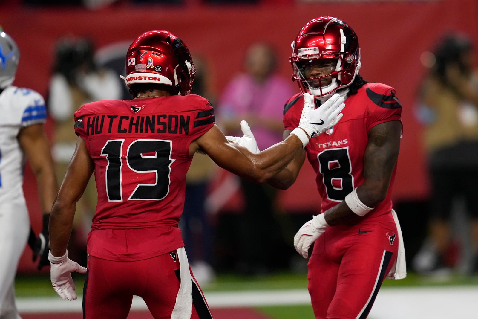 Houston Texans wide receiver John Metchie III (8) celebrates with teammate Xavier Hutchinson (19) after catching a 15-yard touchdown pass during the first half of an NFL football game against the Detroit Lions, Sunday, Nov. 10, 2024, in Houston. (AP Photo/David J. Phillip)