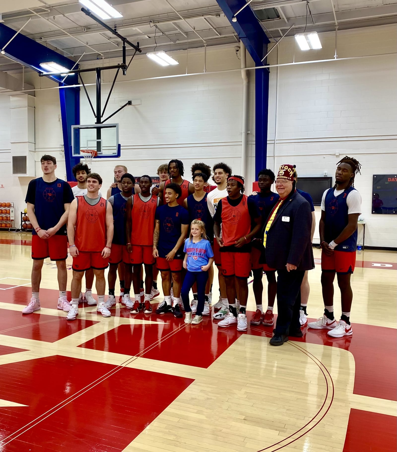 Six-year-old Parker Roche, a first grader at Anna Elementary School, and the Dayton Flyers after practice at the Cronin Center gym. CONTRIBUTED