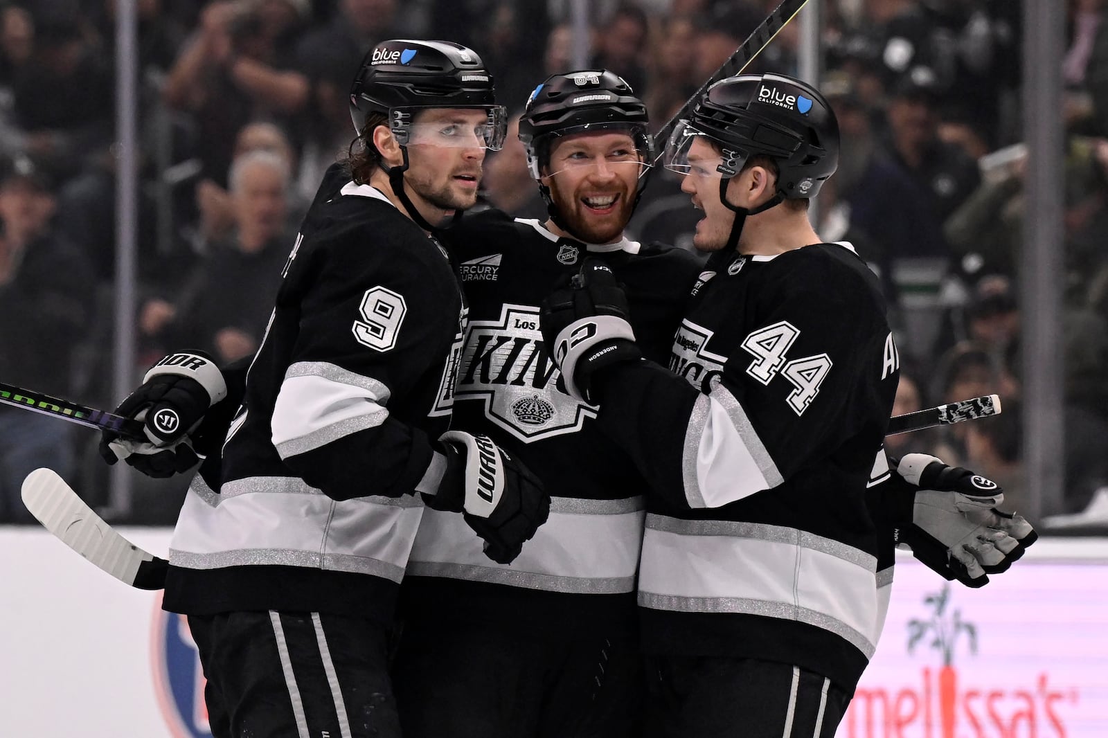 Los Angeles Kings defenseman Vladislav Gavrikov (84) celebrates scoring a goal with right wing Adrian Kempe (9) and defenseman Mikey Anderson (44) against the Columbus Blue Jackets during the second period of an NHL hockey game in Los Angeles, Saturday, Nov. 9, 2024. (AP Photo/Alex Gallardo)