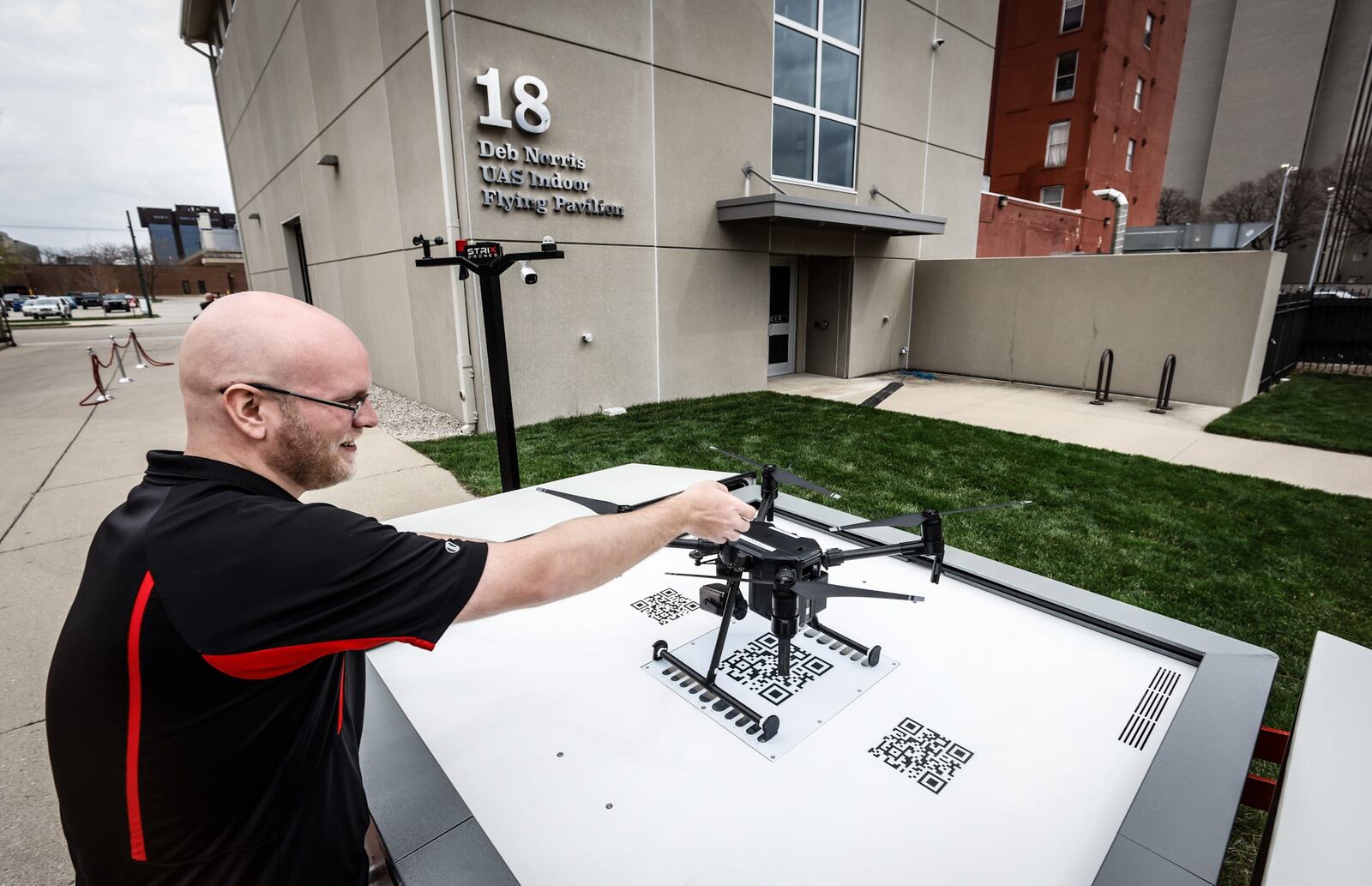 Sinclair College student, Sam Heckel, positions a drone in a docking station that will be manufactured in the Dayton area. The stations will expand and extend the reach of drones. JIM NOELKER/STAFF