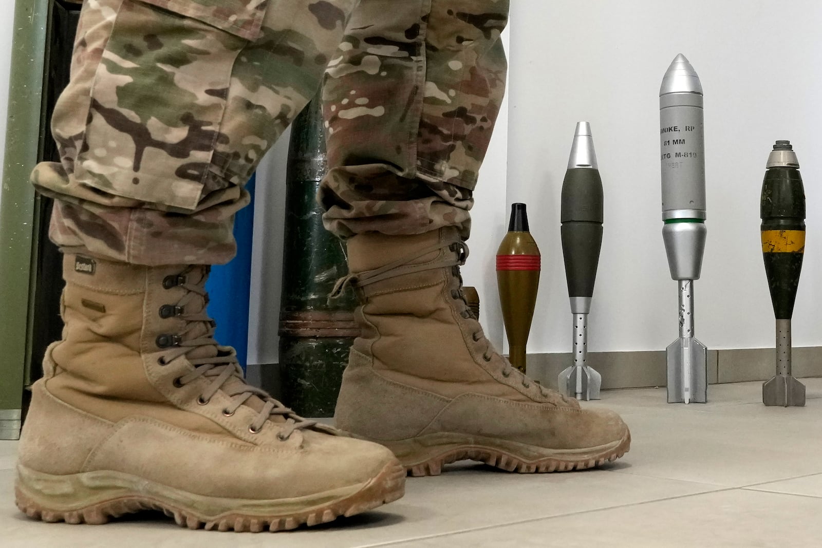 A Cypriot National Guardsman stands in front of a display of inert rockets, artillery shells and other munitions as part of a training course of Ukrainian personnel in the disposal of landmines and other explosive ordnance in Cyprus, at an army base in Nicosia, Thursday, Nov. 14, 2024. (AP Photo/Petros Karadjias)