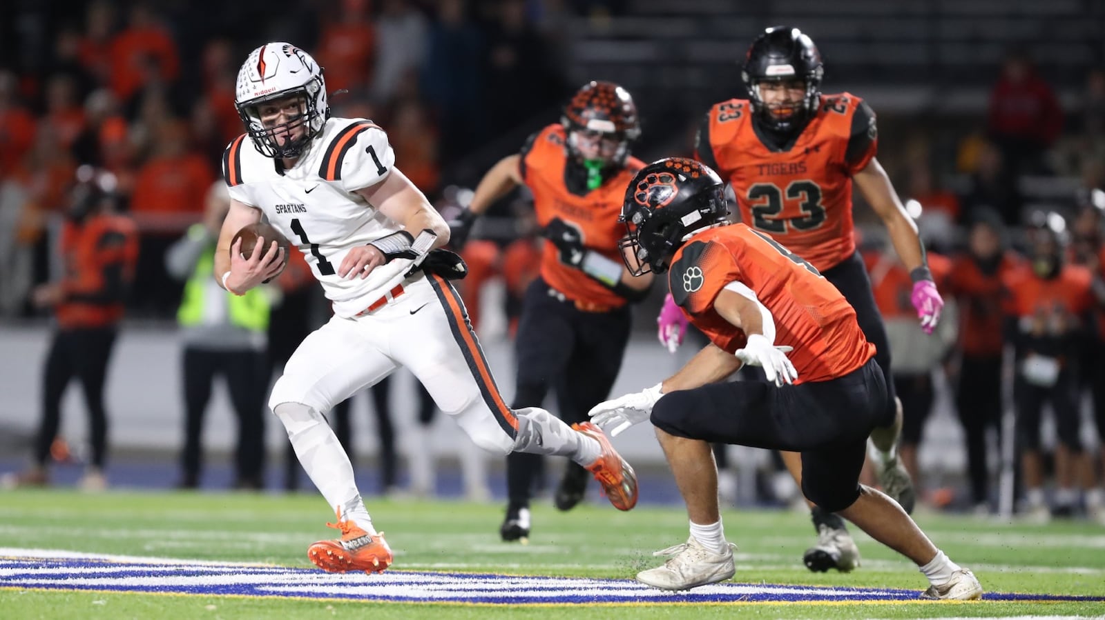 Waynesville High School senior quarterback Alex Amburgy runs past West Liberty-Salem senior Josiah Stidham during their game on Friday night at Dayton Welcome Stadium. The Tigers won 45-42. Michael Cooper/CONTRIBUTED