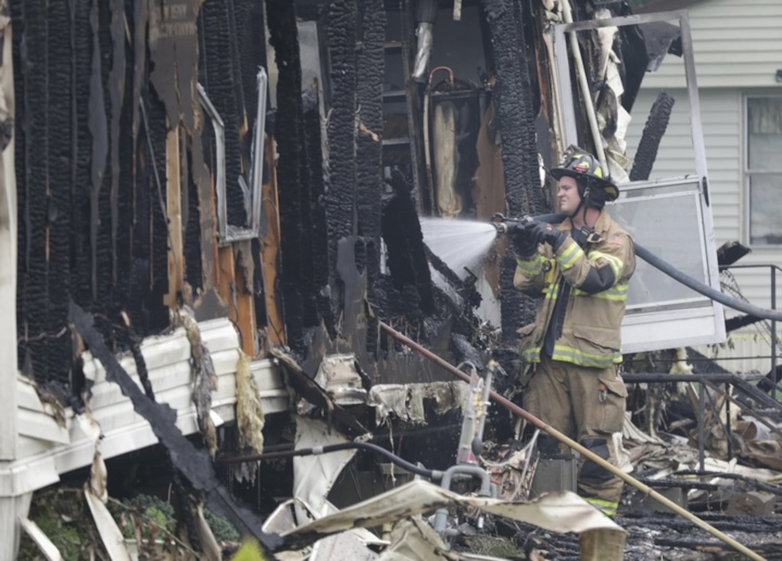 A fire finishes putting out the trailer fire in the Harmony Estates mobile home park Sunday. BILL LACKEY/STAFF