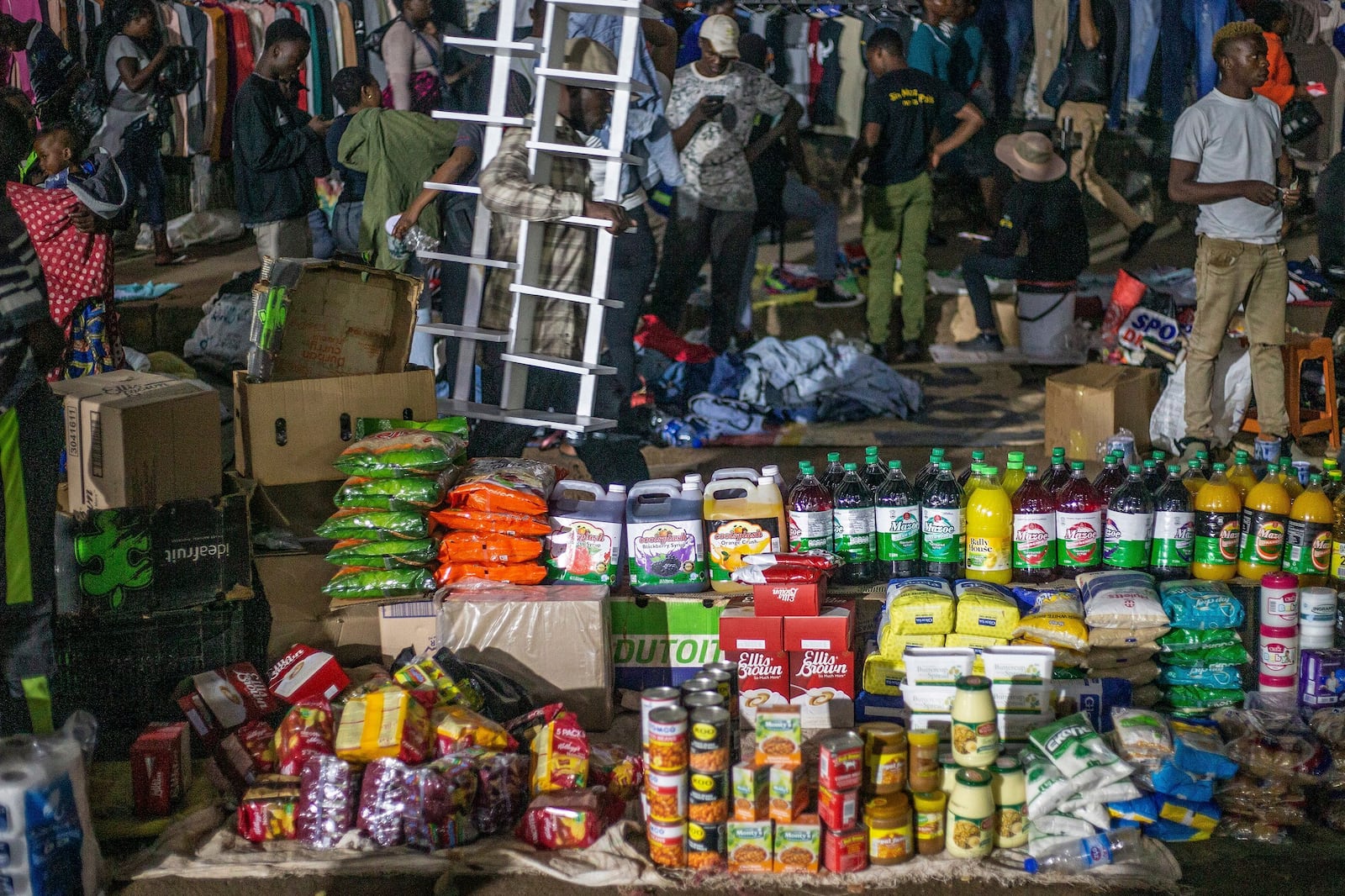 People shop at informal and illegal markets that pop up at night to avoid police raids in central Harare, Zimbabwe, Friday, Nov. 11, 2024. (AP Photo/Aaron Ufumeli)