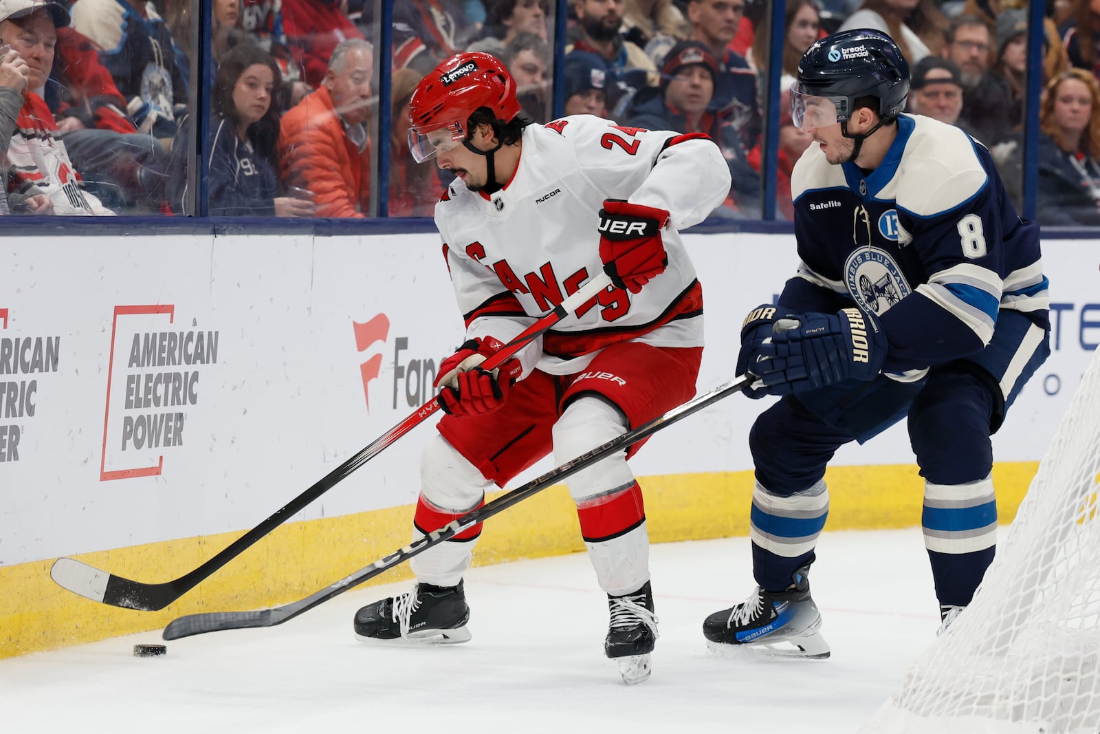 Carolina Hurricanes' Seth Jarvis, left, controls the puck in front of Columbus Blue Jackets' Zach Werenski, right, during the first period of an NHL hockey game Tuesday, Dec. 31, 2024, in Columbus, Ohio. (AP Photo/Jay LaPrete)