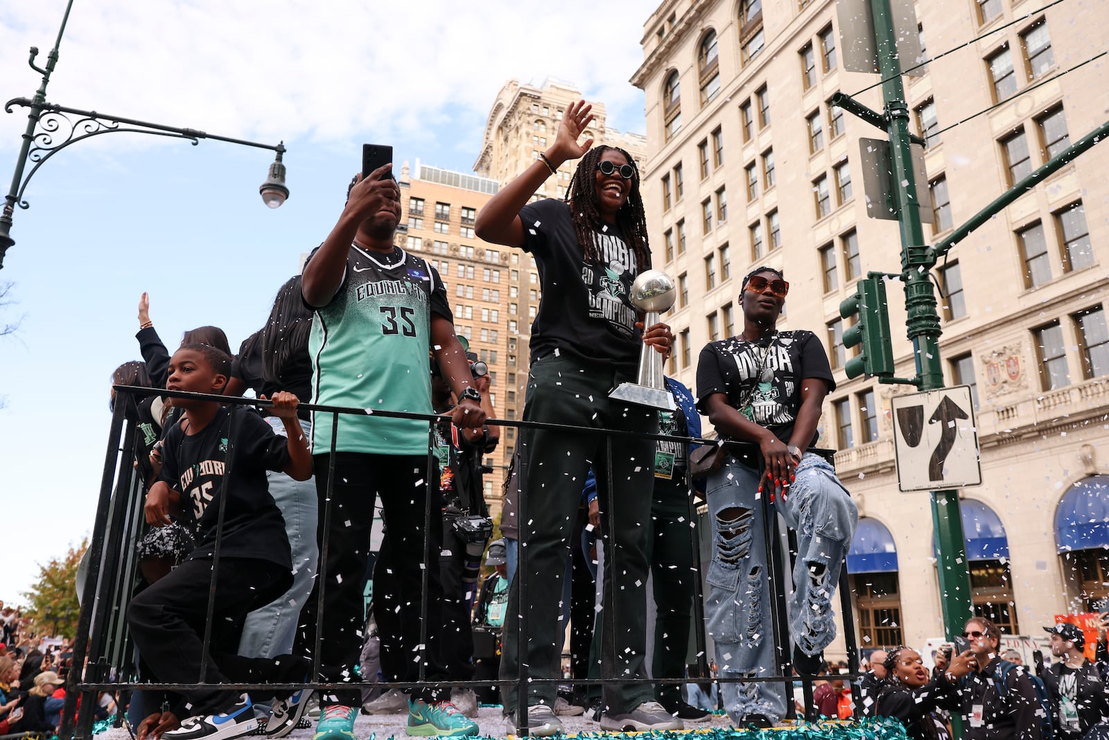 New York Liberty forward Jonquel Jones, center, waves as she rides on a float holding the MVP trophy to celebrate the team's WNBA basketball championship over the Minnesota Lynx, Thursday, Oct. 24, 2024, in New York. (AP Photo/Yuki Iwamura)