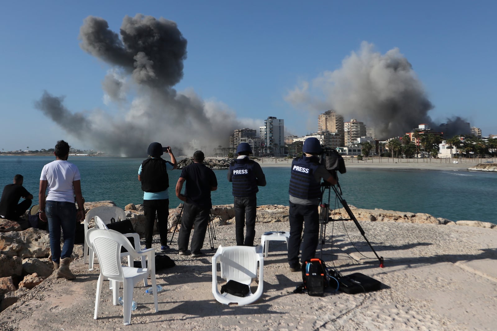 FILE - Journalists film as smoke rises from buildings hit in Israeli airstrikes in Tyre, southern Lebanon, on Oct. 28, 2024. (AP Photo/Mohammed Zaatari, File)