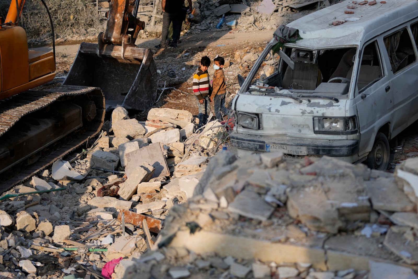 Two boys observe the site where an Israeli airstrike hit a house in Aalmat village, northern Lebanon, Sunday, Nov. 10, 2024. (AP Photo/Hassan Ammar)