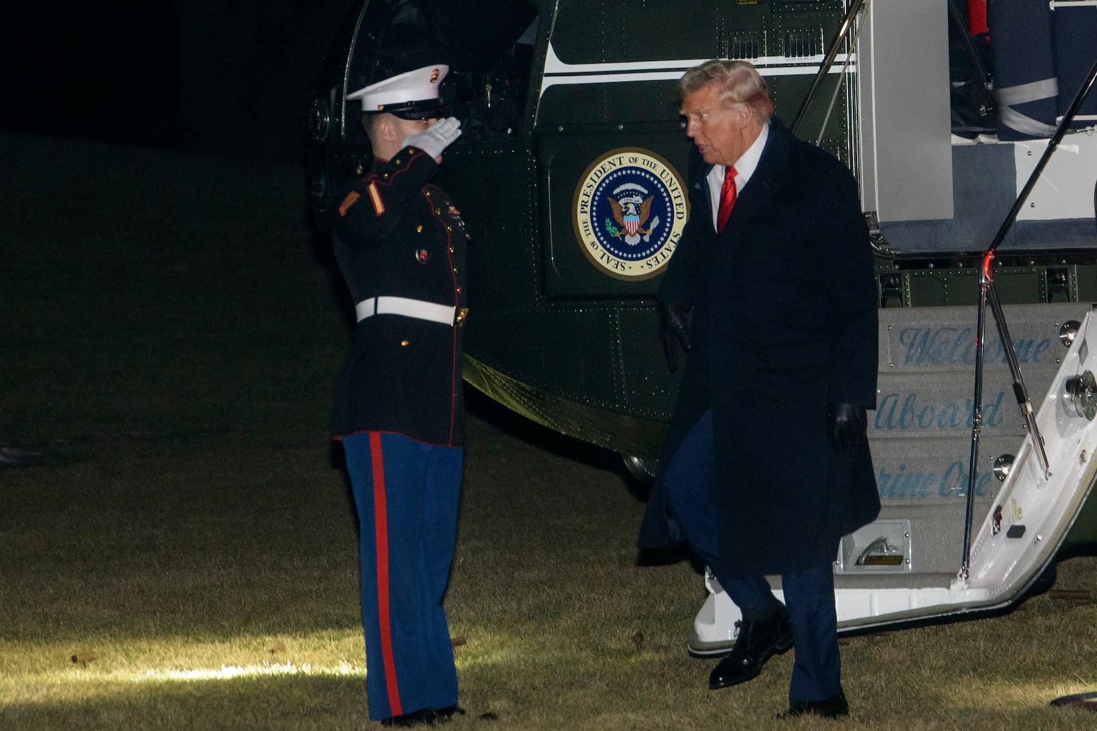 President Donald Trump greets a Marine Corps honor guard as he disembarks Marine One upon arrival on the South Lawn of the White House in Washington, Monday, Jan. 27, 2025. (AP Photo/Rod Lamkey, Jr.)