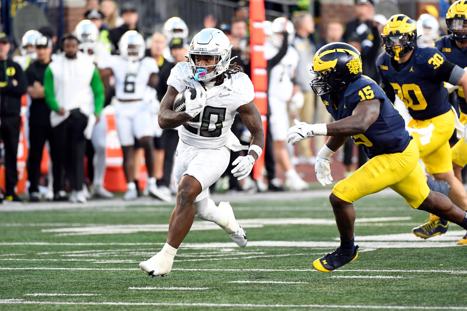 Oregon running back Jordan James, left, carries with the ball as Michigan linebacker Ernest Hausmann pursues during the second half of an NCAA college football game, Saturday, Nov. 2, 2024, in Ann Arbor, Mich. Oregon defeated Michigan 38-17. (AP Photo/Jose Juarez)