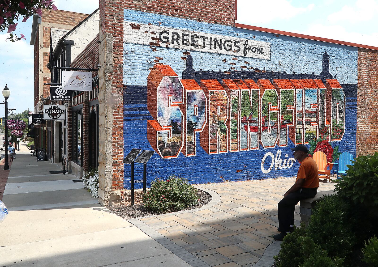 A man sits in the shade in the small pocket park along Fountain Avenue Monday, July 11, 2022. Fountain Avenue has seen several new retail and restaurants open in recent years. BILL LACKEY/STAFF