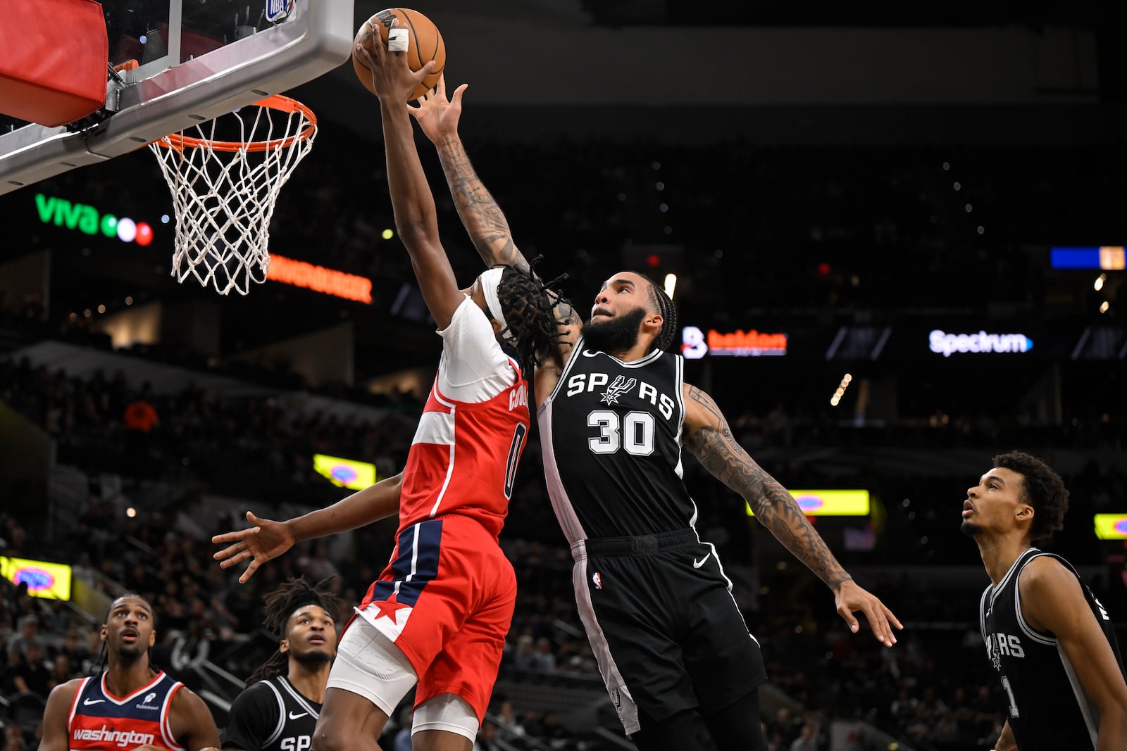 Washington Wizards' Bilal Coulibaly (0) goes to the basket against San Antonio Spurs' Julian Champagnie (30) during the first half of an NBA basketball game, Thursday, Nov. 13, 2024, in San Antonio. (AP Photo/Darren Abate)