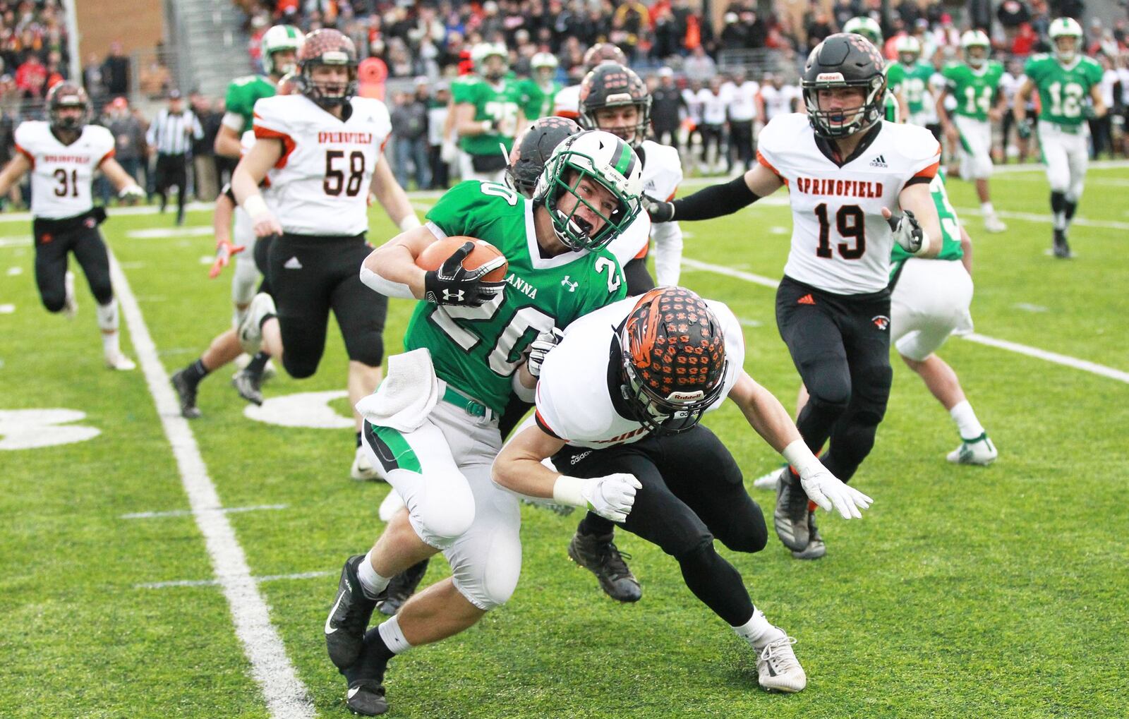 Anna’s Riley Huelskamp (20) battles for yardage agaisnt New Middletown Springfield in Friday’s Division VI state champisonship game at Tom Benson Hall of Fame Stadium in Canton. Marc Pendleton/STAFF