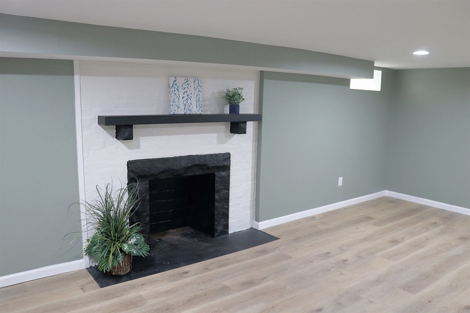 A wood-burning fireplace has stone and brick surround plus a wood mantel. 