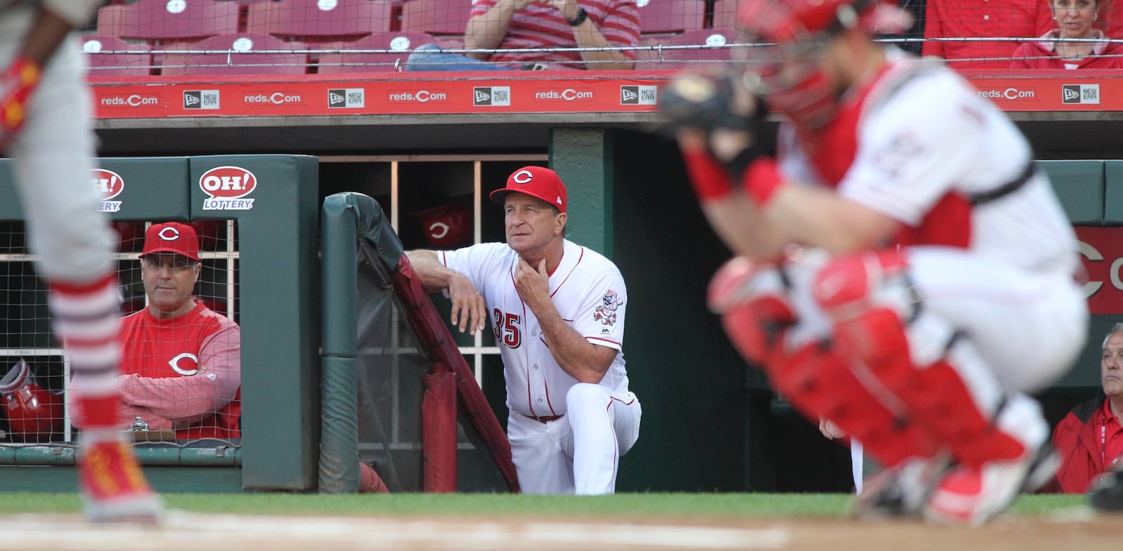 Reds bench coach Jim Riggleman, center, and manager Bryan Price, left, watch a game against the Cardinals on Thursday, April 12, 2018, at Great American Ball Park in Cincinnati.