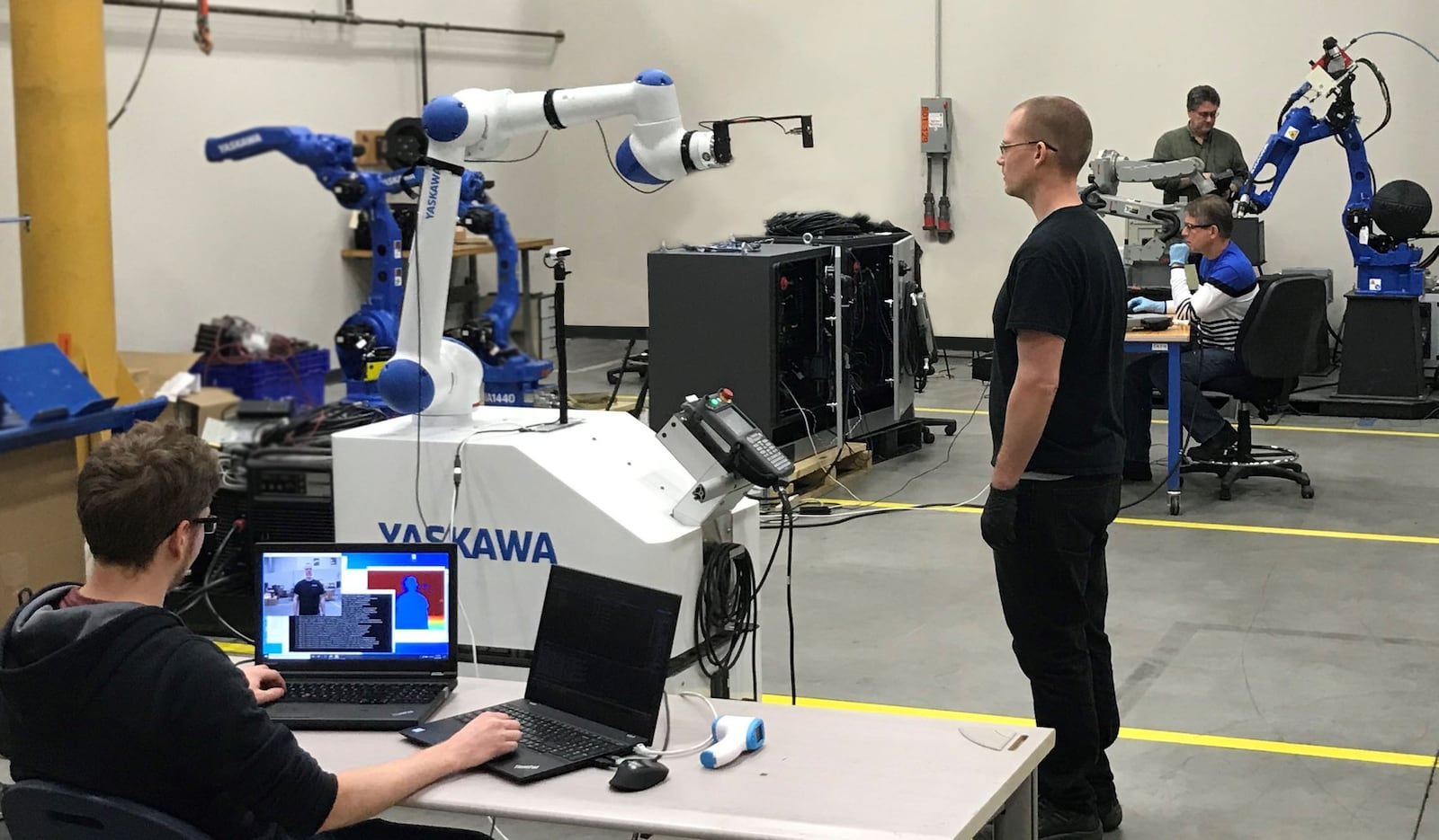 Yaskawa Motoman employees practice social distancing while testing robot equipment, including a collaborative robot that will have the ability to take employees temperatures when they arrive to work at the Miamisburg firm. From left are Matthew Hartshorn, Jayson Noll, John Elliott and Greg Morgan.