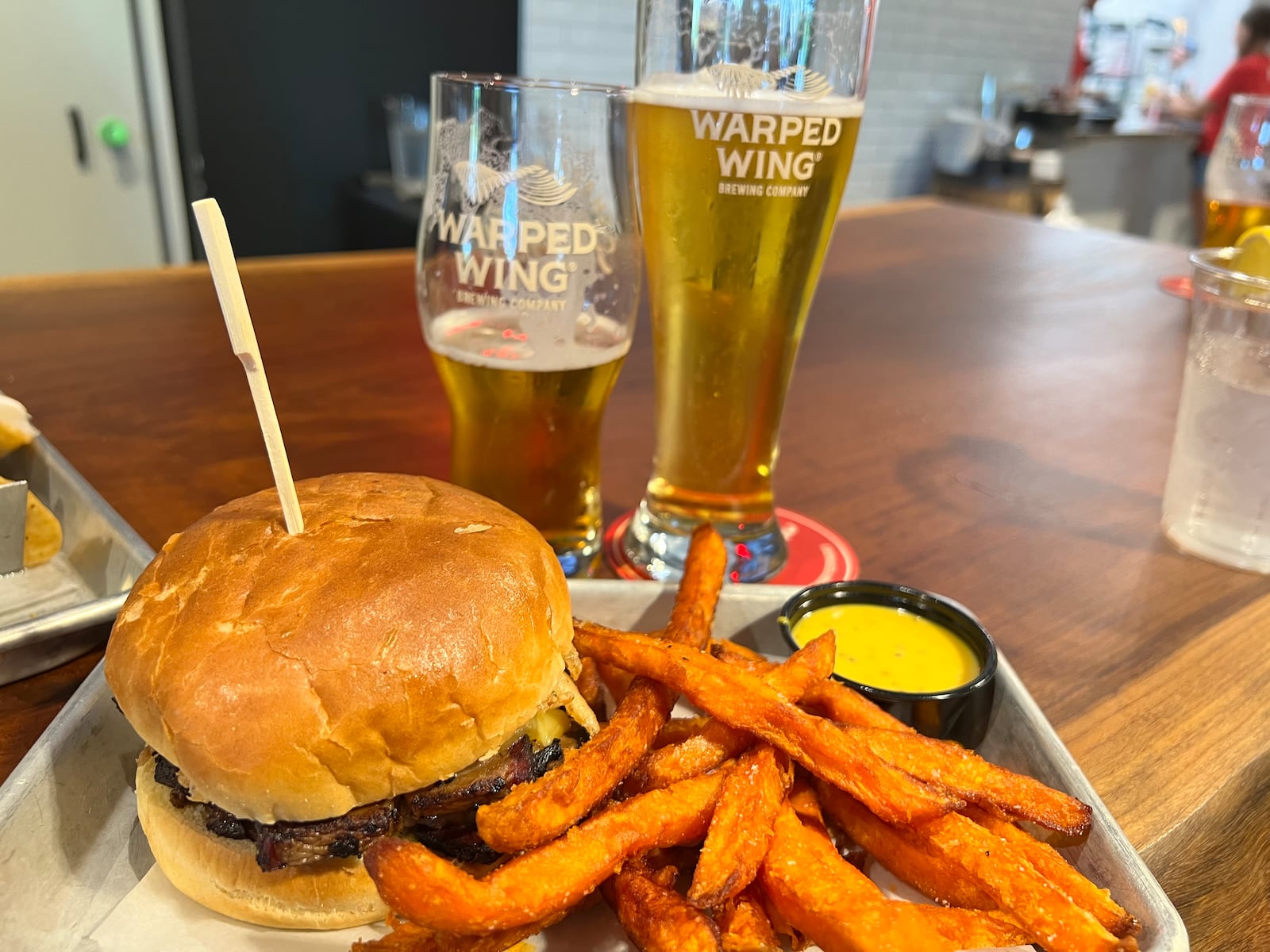 Brisket sandwich served with sweet potato fries at Warped Wing Brewery & Smokery in Huber Heights. ALEXIS LARSEN/CONTRIBUTOR