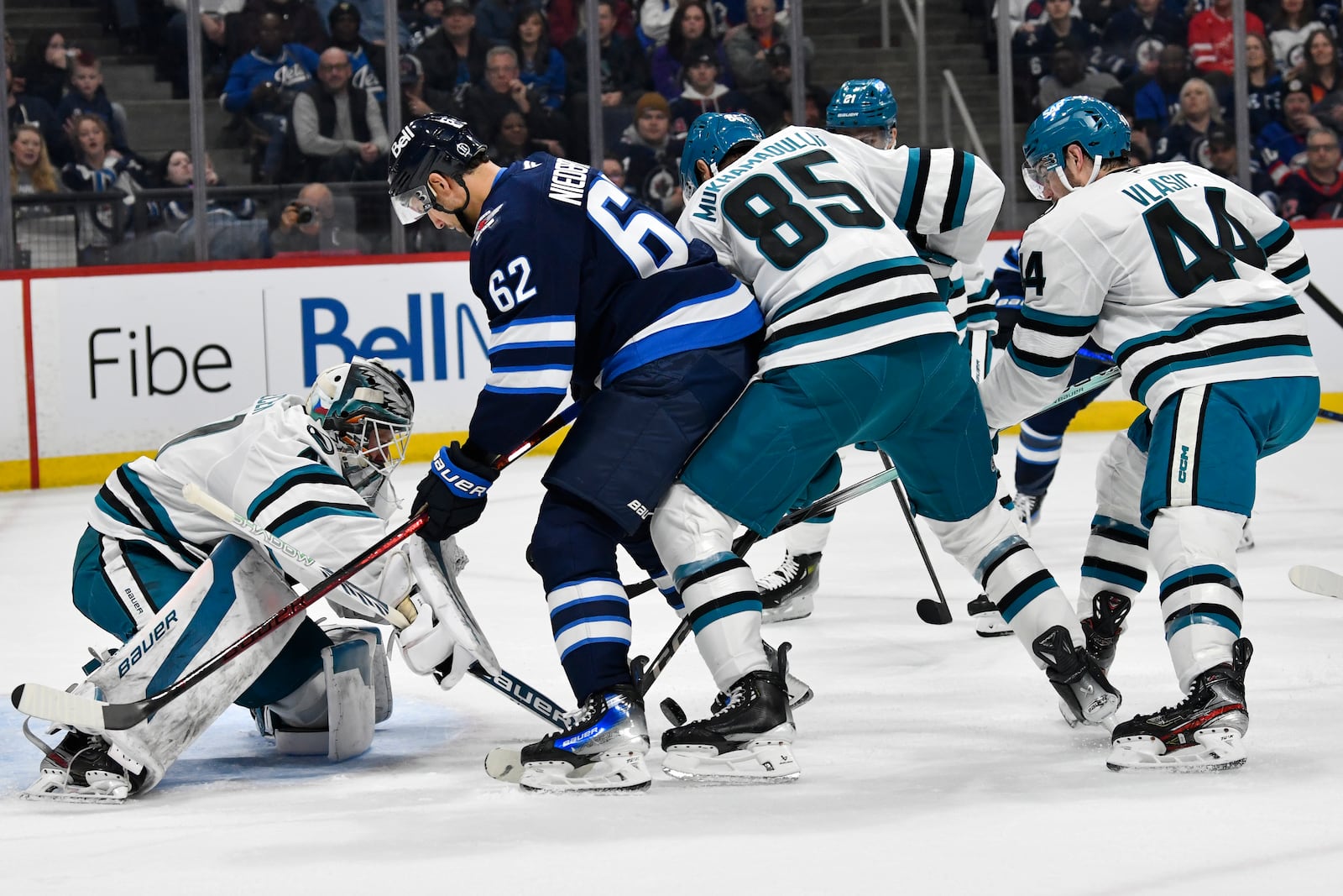 San Jose Sharks' goaltender Vitek Vanecek (41) makes a save on Winnipeg Jets' Nino Niederreiter (62) as Shakir Mukhamadullin (85) and Marc-Edouard Vlasic (44) defend during the second period of an NHL hockey game in Winnipeg, Manitoba, Monday, Feb. 24, 2025. (Fred Greenslade/The Canadian Press via AP)