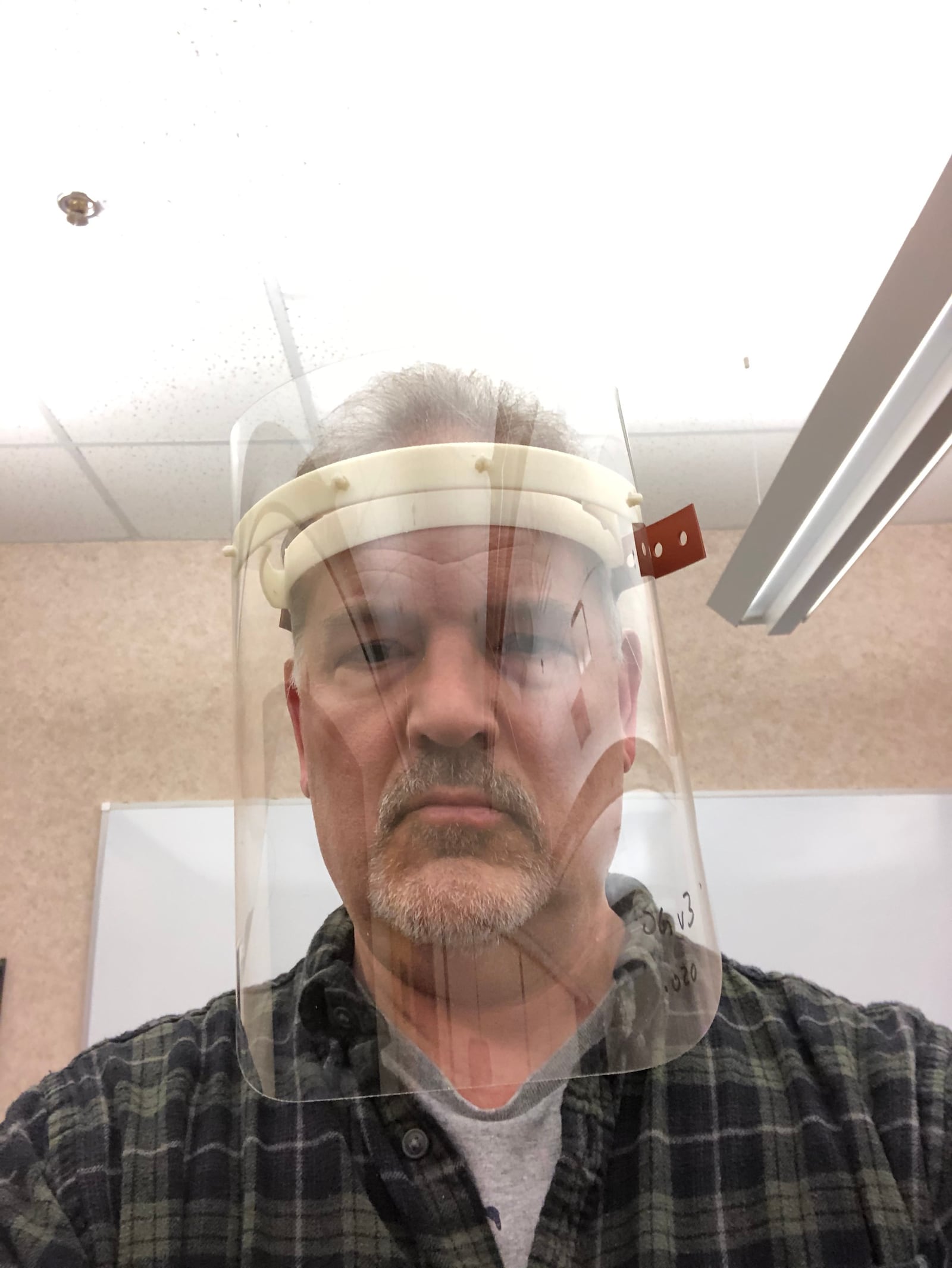 Mike Pintz, with the Magnet MEP manufacturering consultant in Cleveland, demonstrates a prototype face shield that Ohio manufacturers have banded togther to make. 