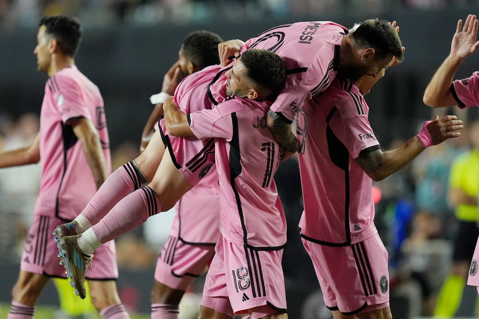 Inter Miami defender Jordi Alba (18) lifts Inter Miami forward Lionel Messi (10) after Alba scored a goal during the second half of match one of their MLS playoff opening round soccer match against Atlanta United, Friday, Oct. 25, 2024, in Fort Lauderdale, Fla. (AP Photo/Rebecca Blackwell)