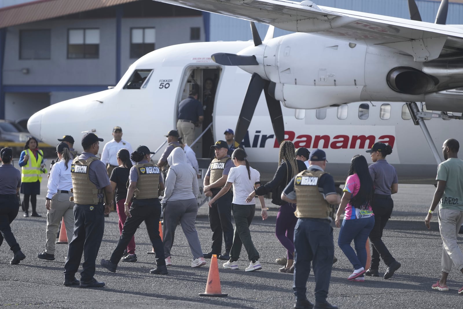 People arrive to board a repatriation flight bound for Colombia at Albrook Airport in Panama City, Monday, Feb. 3, 2025. (AP Photo/Mark Schiefelbein, Pool)