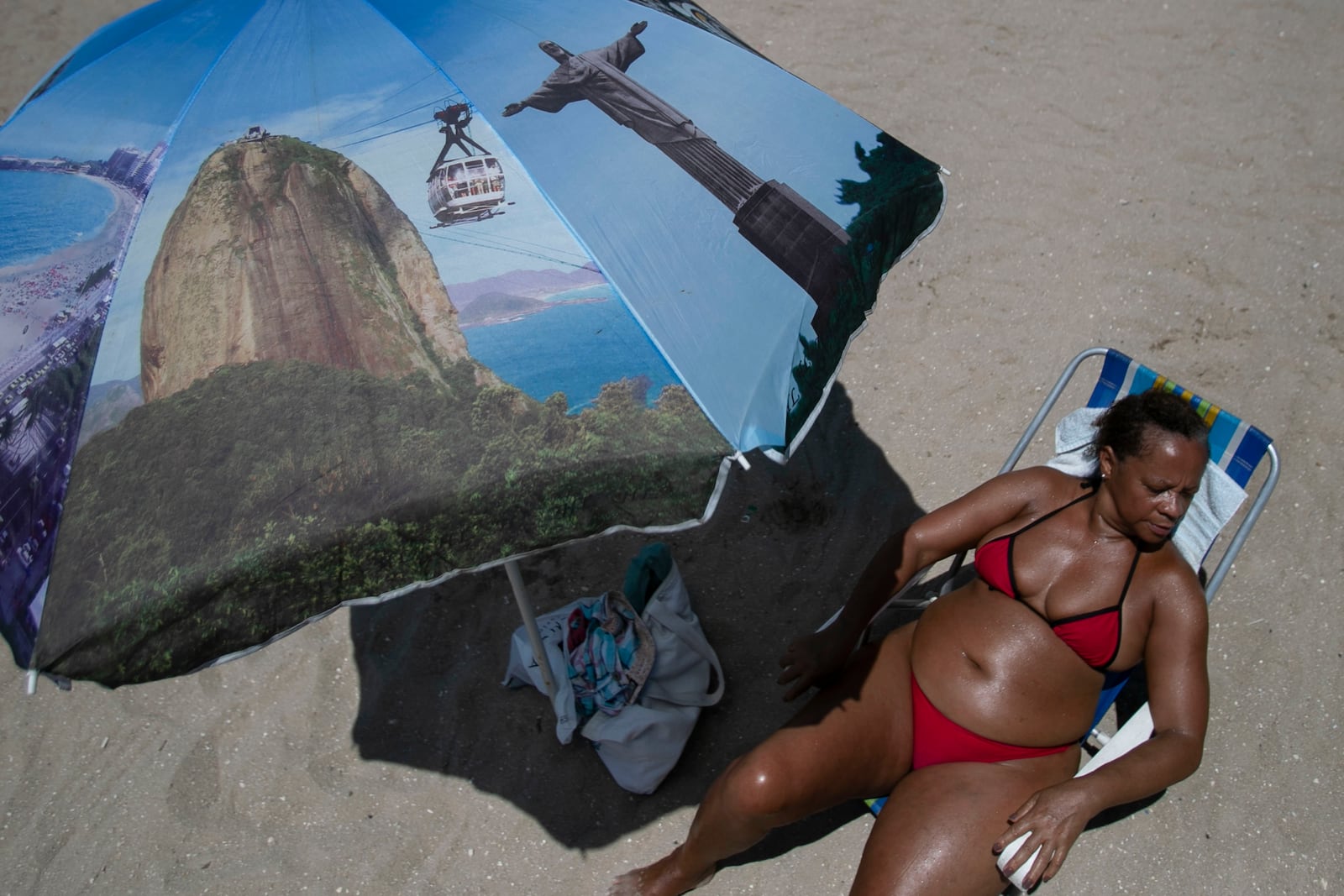 A women sunbathes at the Piscinao de Ramos artificial beach during summer in Rio de Janeiro, Sunday, Feb. 16, 2025. (AP Photo/Bruna Prado)