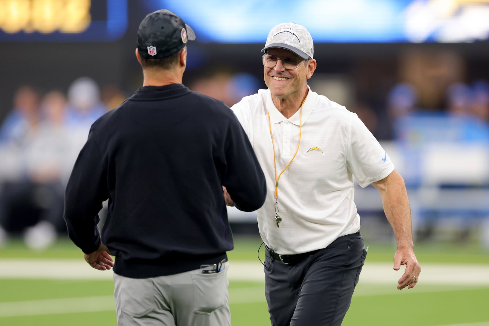 Los Angeles Chargers head coach Jim Harbaugh, right, shakes hands with his brother, Baltimore Ravens Head Coach John Harbaugh, before an NFL football game Monday, Nov. 25, 2024, in Inglewood, Calif. (AP Photo/Ryan Sun)