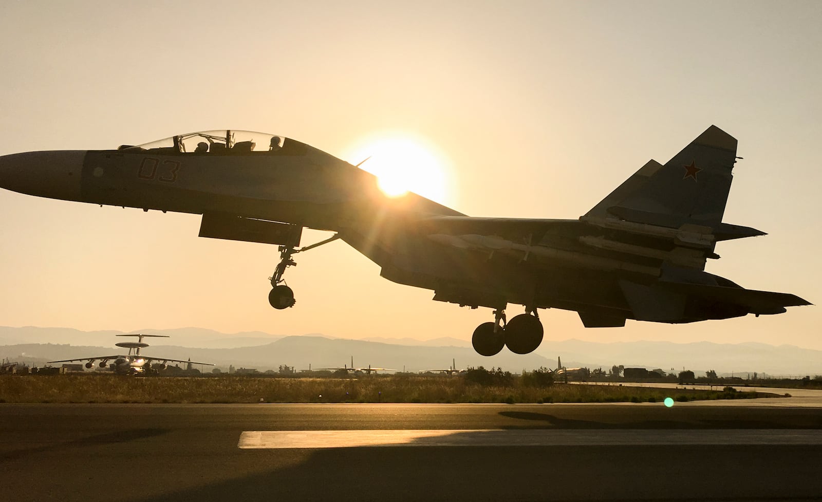 FILE - A Russian warplane lands at Hemeimeem air base in Syria on Sept. 12, 2017. (AP Photo/Nataliya Vasilyeva, File)