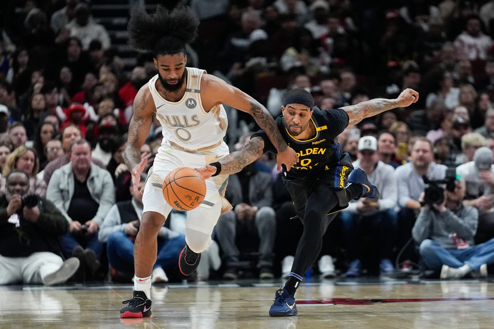 Chicago Bulls guard Coby White, left, and Golden State Warriors guard Gary Payton II, right, chase the ball during the first half of an NBA basketball game Saturday, Feb. 8, 2025, in Chicago. (AP Photo/Erin Hooley)