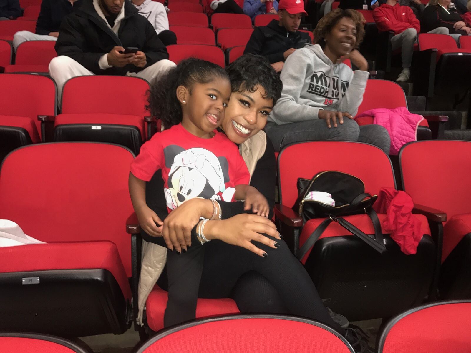 Kilynn Trammell, the girlfriend of Miami senior Darweshi Hunter, and their daughter Melah in the stands at Millett Hall on Saturday. Tom Archdeacon/CONTRIBUTED