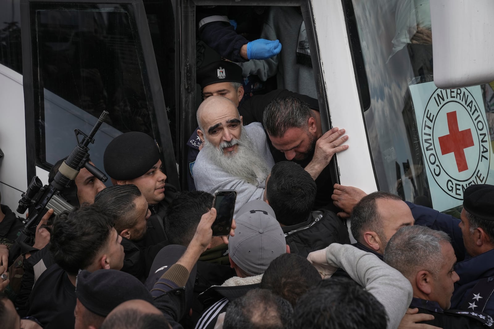 A fragile Palestinian prisoner is helped to exit a Red Cross bus after being released from Israeli prison following a ceasefire agreement between Israel and Hamas, in the West Bank city of Ramallah, Saturday Feb. 1, 2025. (AP Photo/Mahmoud Illean)