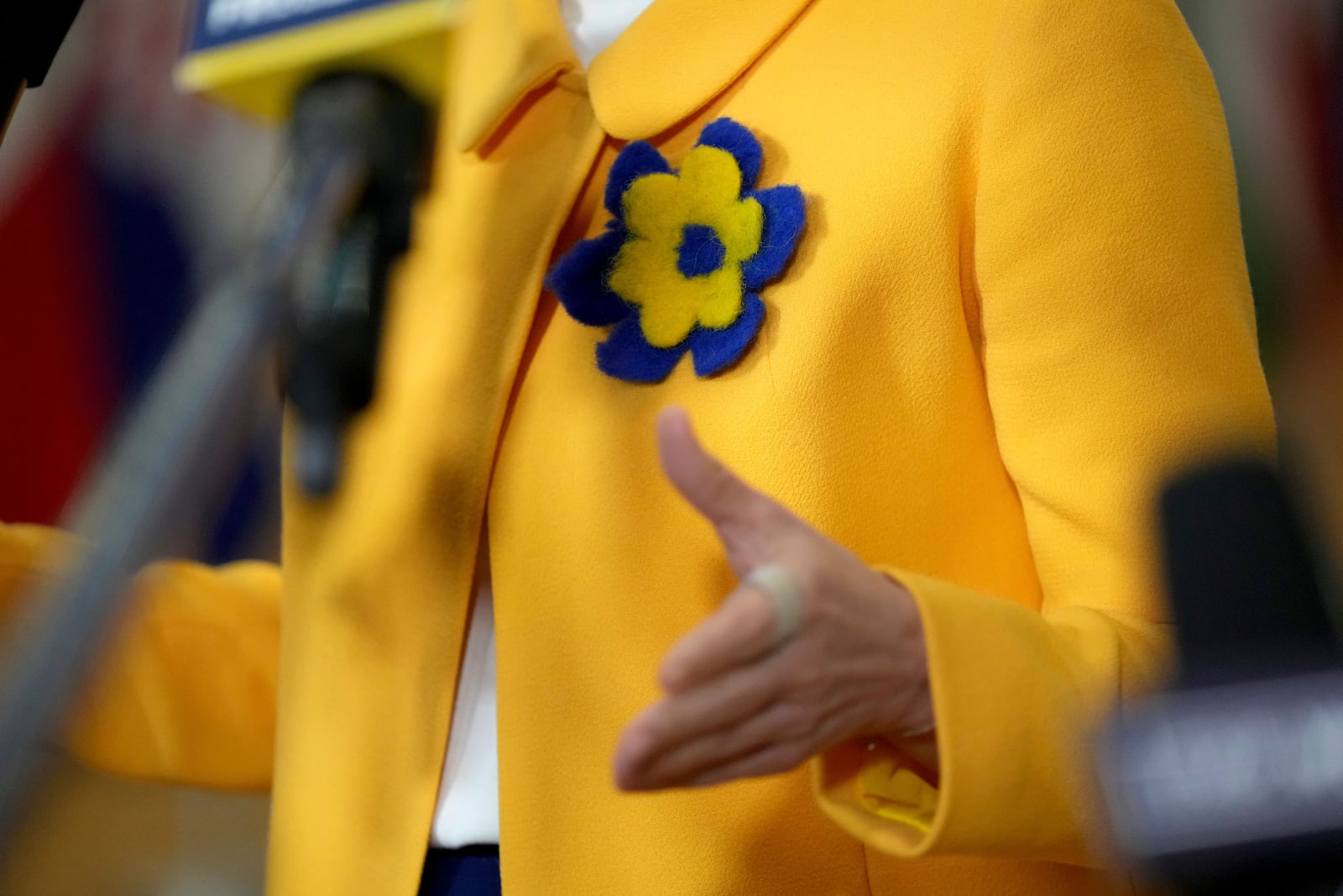 European Union foreign policy chief Kaja Kallas wears a flower in the Ukrainian colors on her jacket as she speaks with the media on arrival for a meeting of EU foreign ministers at the European Council building in Brussels, Monday, Feb. 24, 2025. (AP Photo/Virginia Mayo)