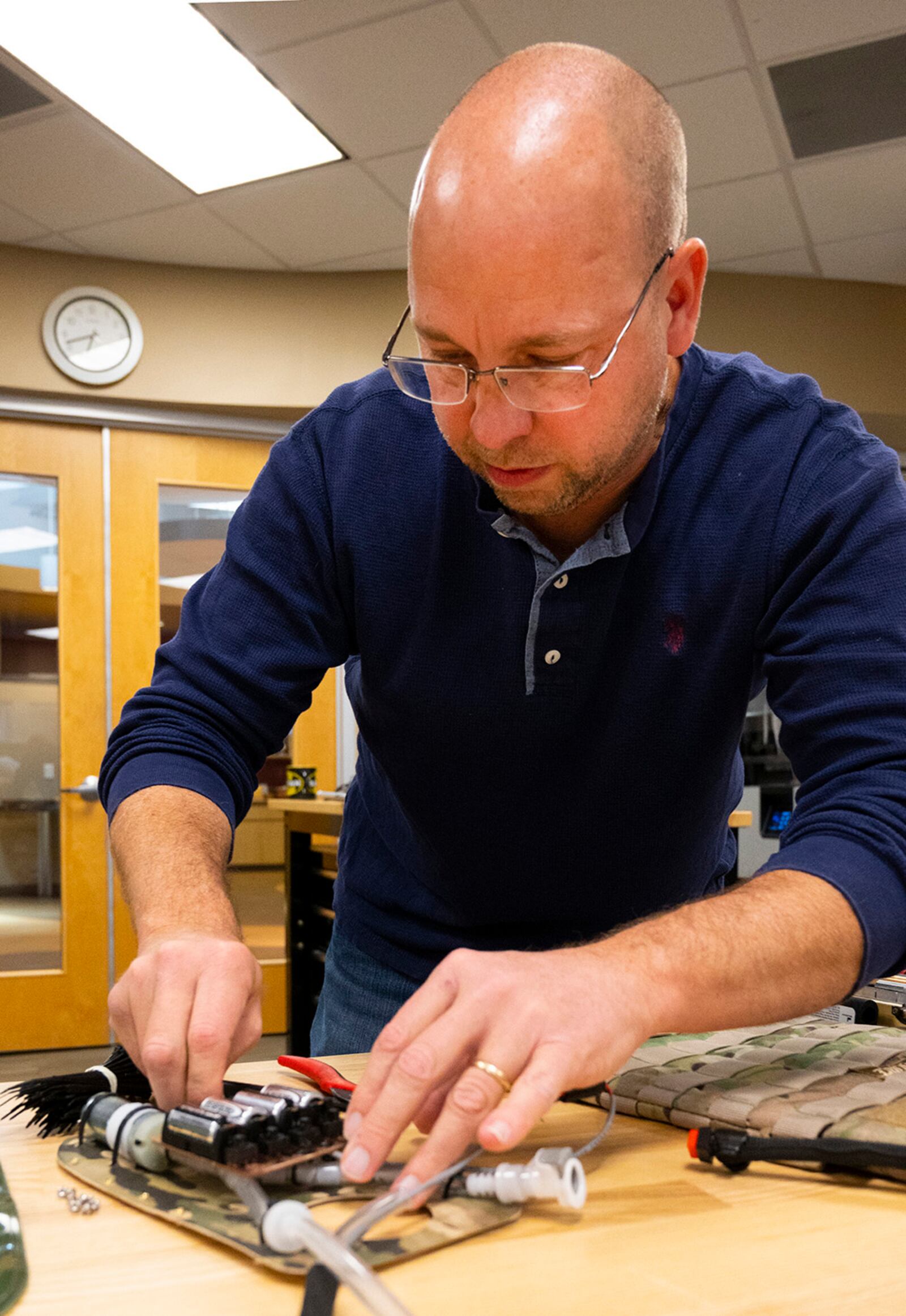 Matthew Sunday, an engineer with the Wright Brothers Institute’s Rapid Innovation Program, works on placing the battery compartment in the liquid-cooled plate carrier prototype Dec. 1 at his lab in Riverside. The system uses a small pump to circulate water and cool military personnel wearing body armor. U.S. AIR FORCE PHOTO/R.J. ORIEZ