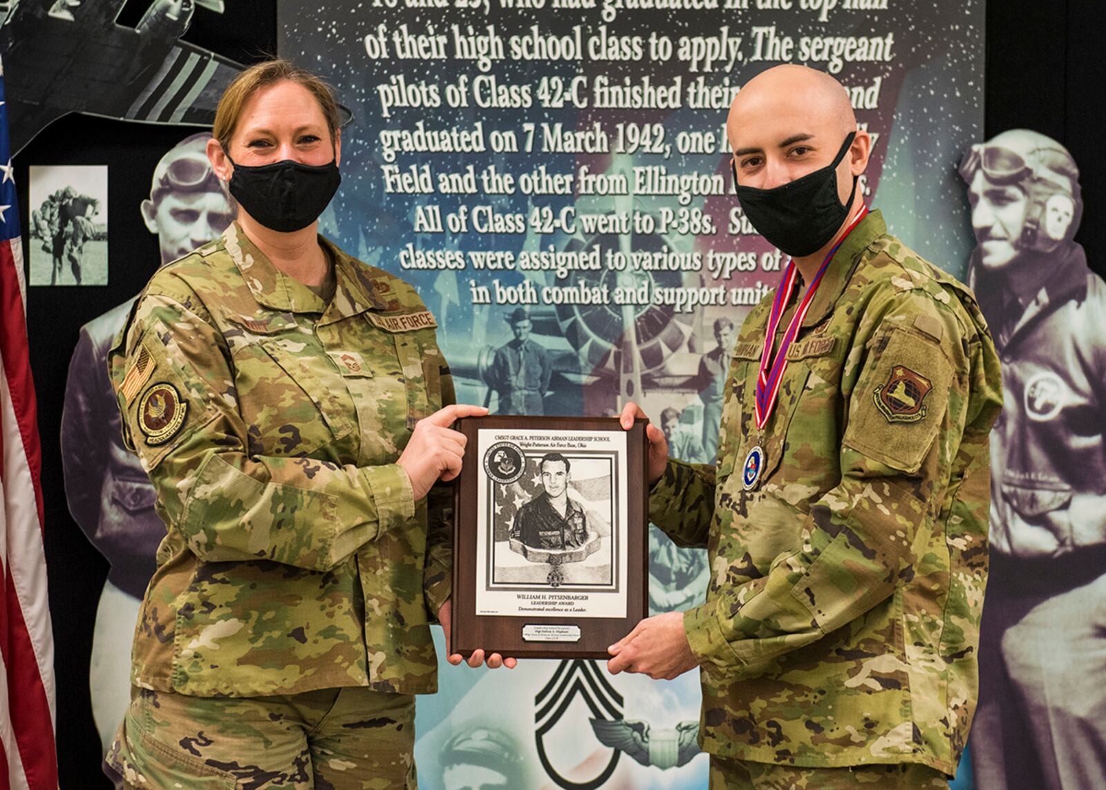 Chief Master Sgt. Lindsey Wolf, Air Force Materiel Command paralegal career field functional manager, presents Staff Sgt. Dalton Oliphant, Signals Analysis Squadron, with the Leadership Award during Airman Leadership School Class 22-B’s graduation ceremony Feb. 10. The award goes to the student who demonstrates leadership excellence. U.S. AIR FORCE PHOTO/JAIMA FOGG