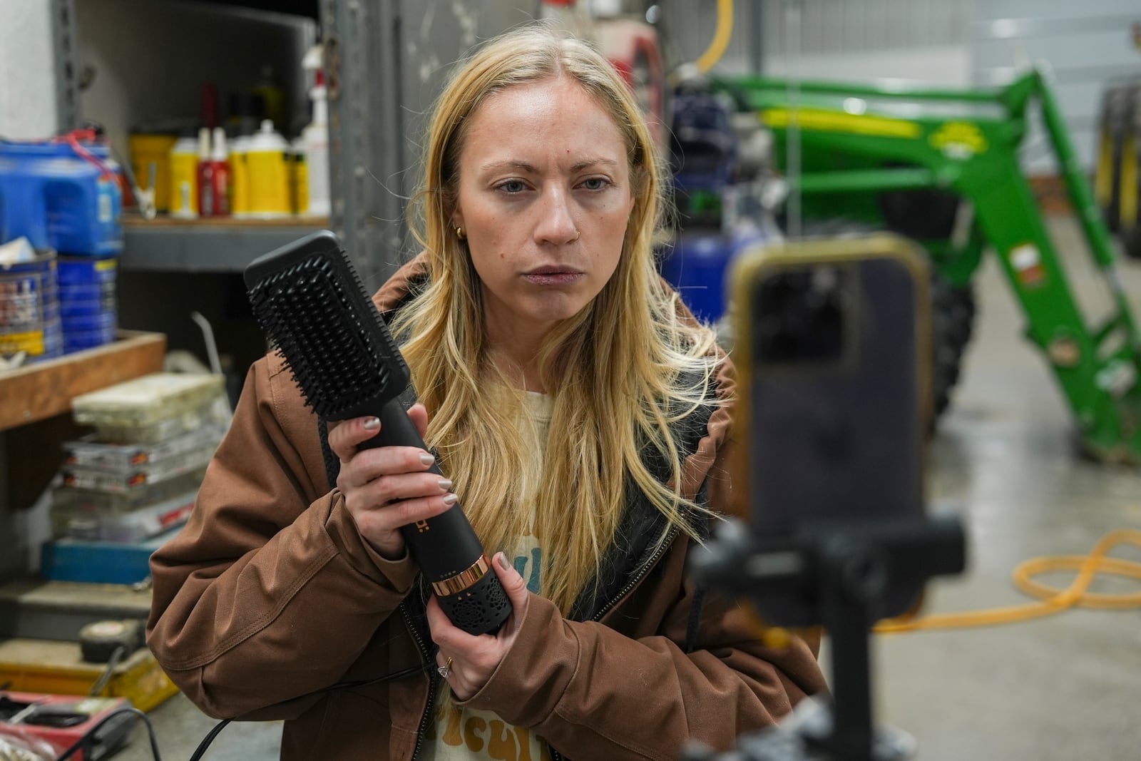 Zoe Kent uses a hair brush as a prop while filming a social media video, Monday, Jan. 20, 2025, at her farm in Bucyrus, Ohio. (AP Photo/Joshua A. Bickel)