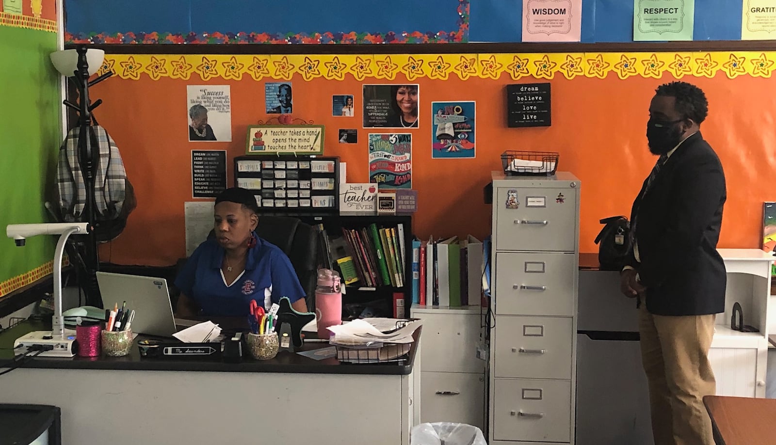 Emerson Academy third-grade teacher Michelle Saunders has a live session with her students through her laptop computer, as Principal Landon Brown observes, Wednesday, Aug. 12, 2020 in Dayton.