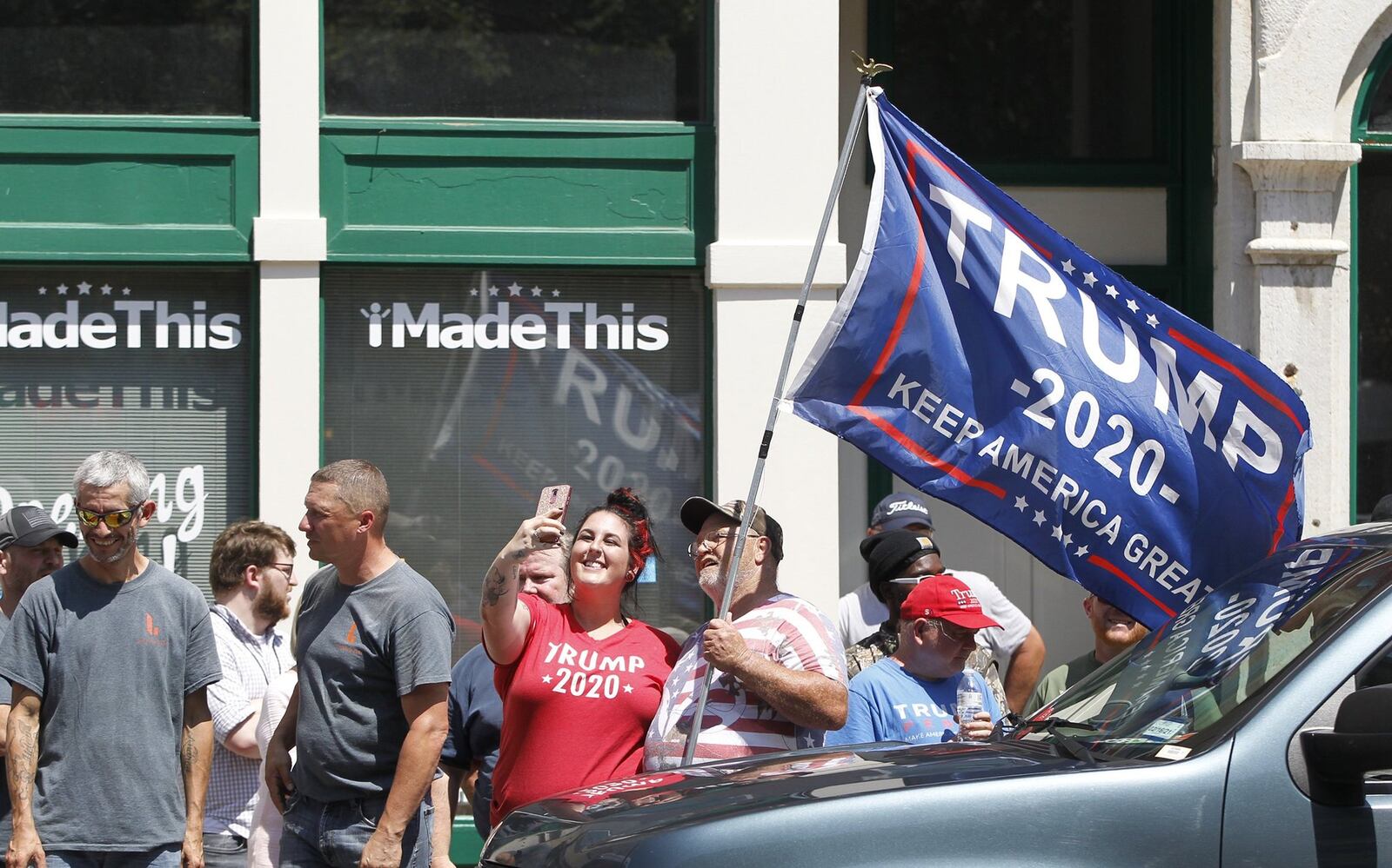 Olivia Whiteman takes a selfie with Jim Stevens, both of Miamisburg, during a demonstration in the Oregon District Wednesday as President Donald Trump and first lady Melania Trump visited the city. The visit came just days after a mass shooting in the district that left nine people dead and dozens injured. LISA POWELL / STAFF