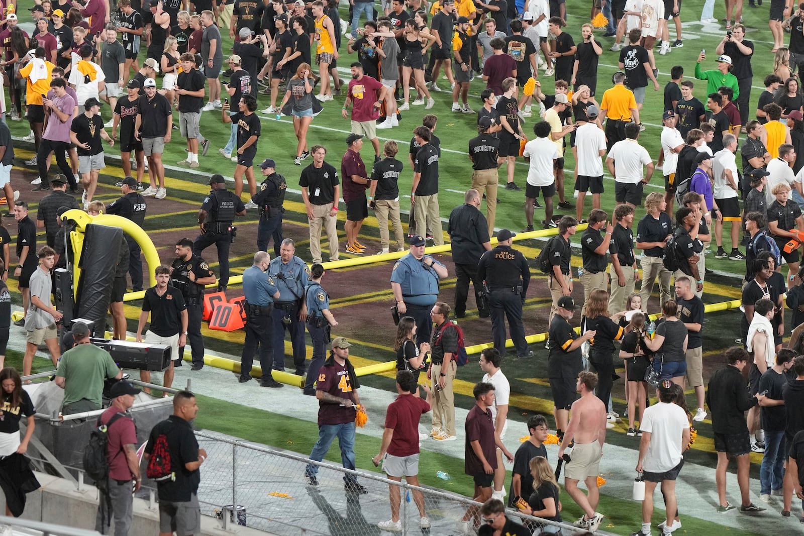 Police officers protect the goal post after Arizona State defeats Utah 27-19 during an NCAA college football game, Friday, Oct. 11, 2024, in Tempe, Ariz. (AP Photo/Rick Scuteri)